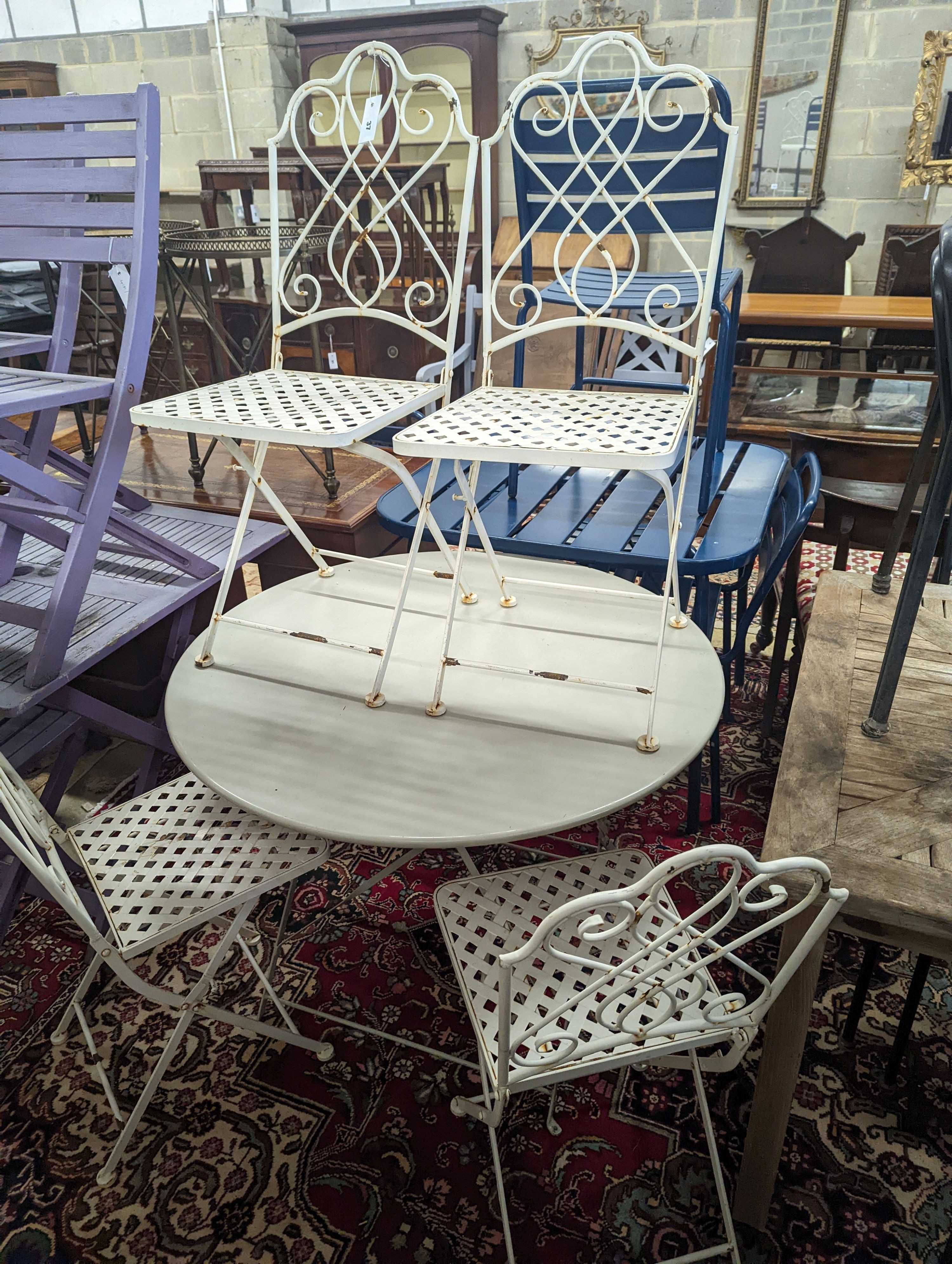 A painted metal circular folding garden table, diameter 94cm, height 72cm and four metal folding chairs