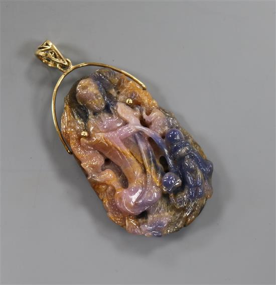 A gold mounted corundum pendant carved with the figure of Guan Yin, 56mm. A gold mounted corundum pendant carved with the figure of Guan Yin, 56mm.