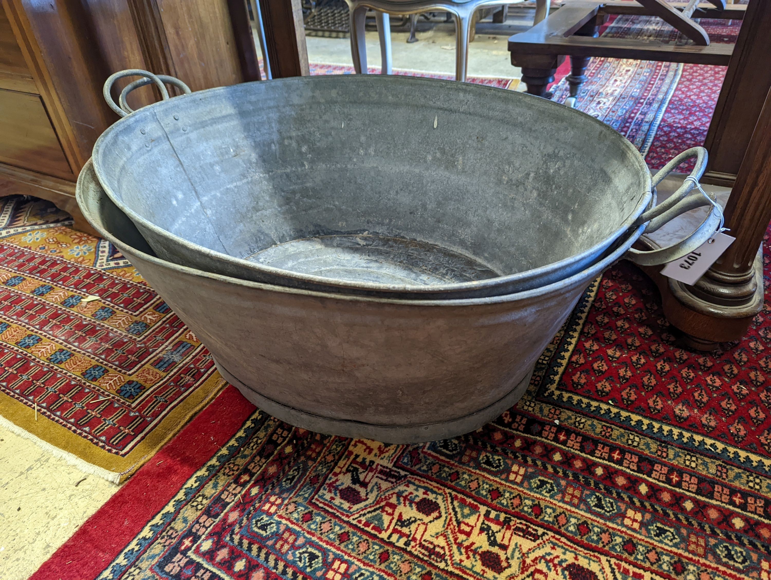 Two large oval galvanised tubs, larger width 89cm