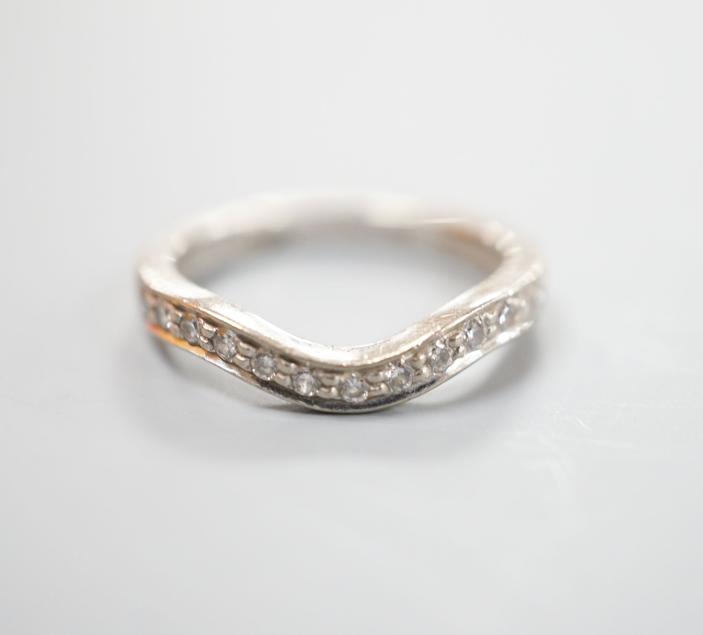 A modern 18ct white gold and diamond set shaped half eternity ring, size H/I, gross weight 3.3 grams.