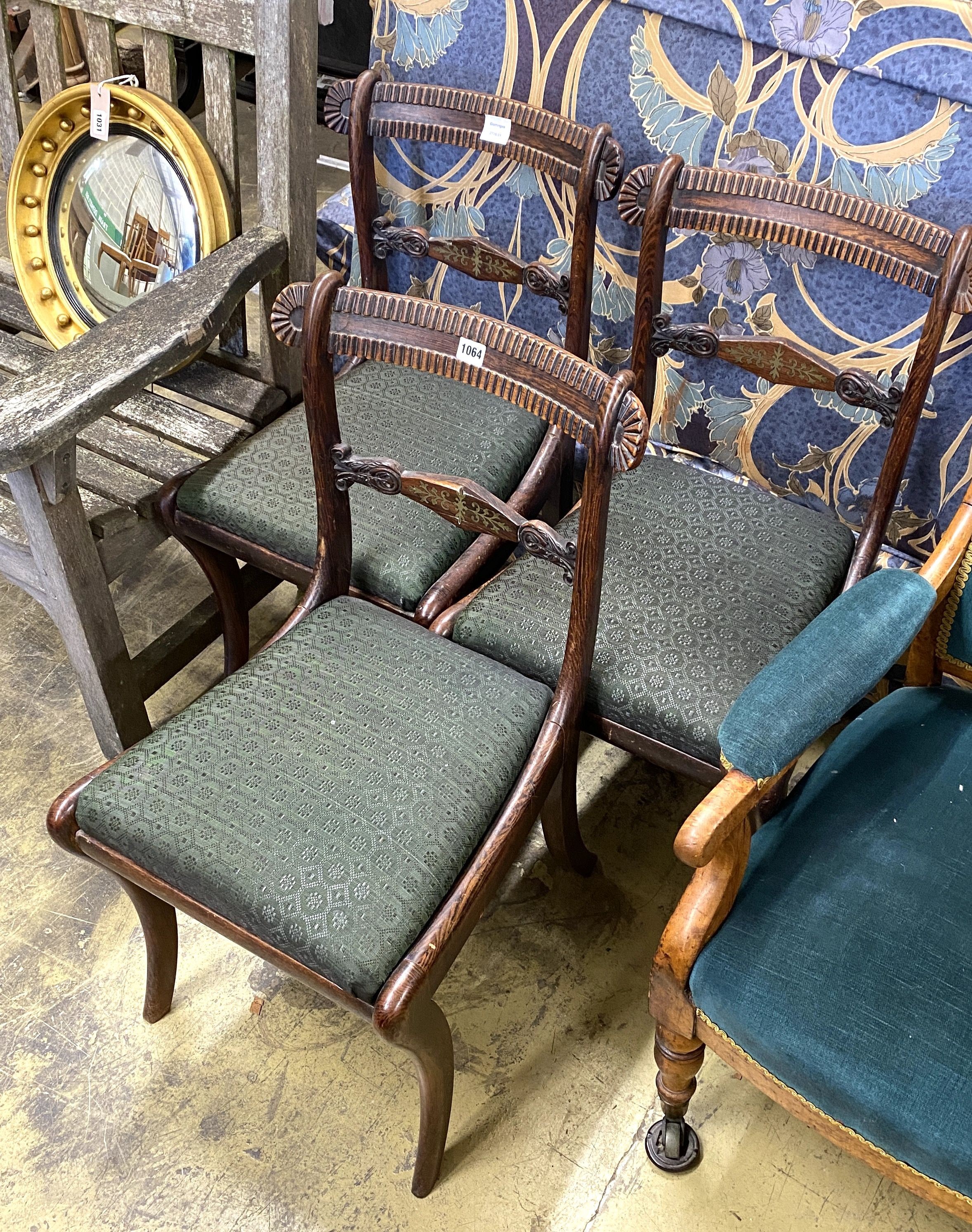 A set of three Regency simulated rosewood dining chairs, with brass-inlaid rails and sabre legs