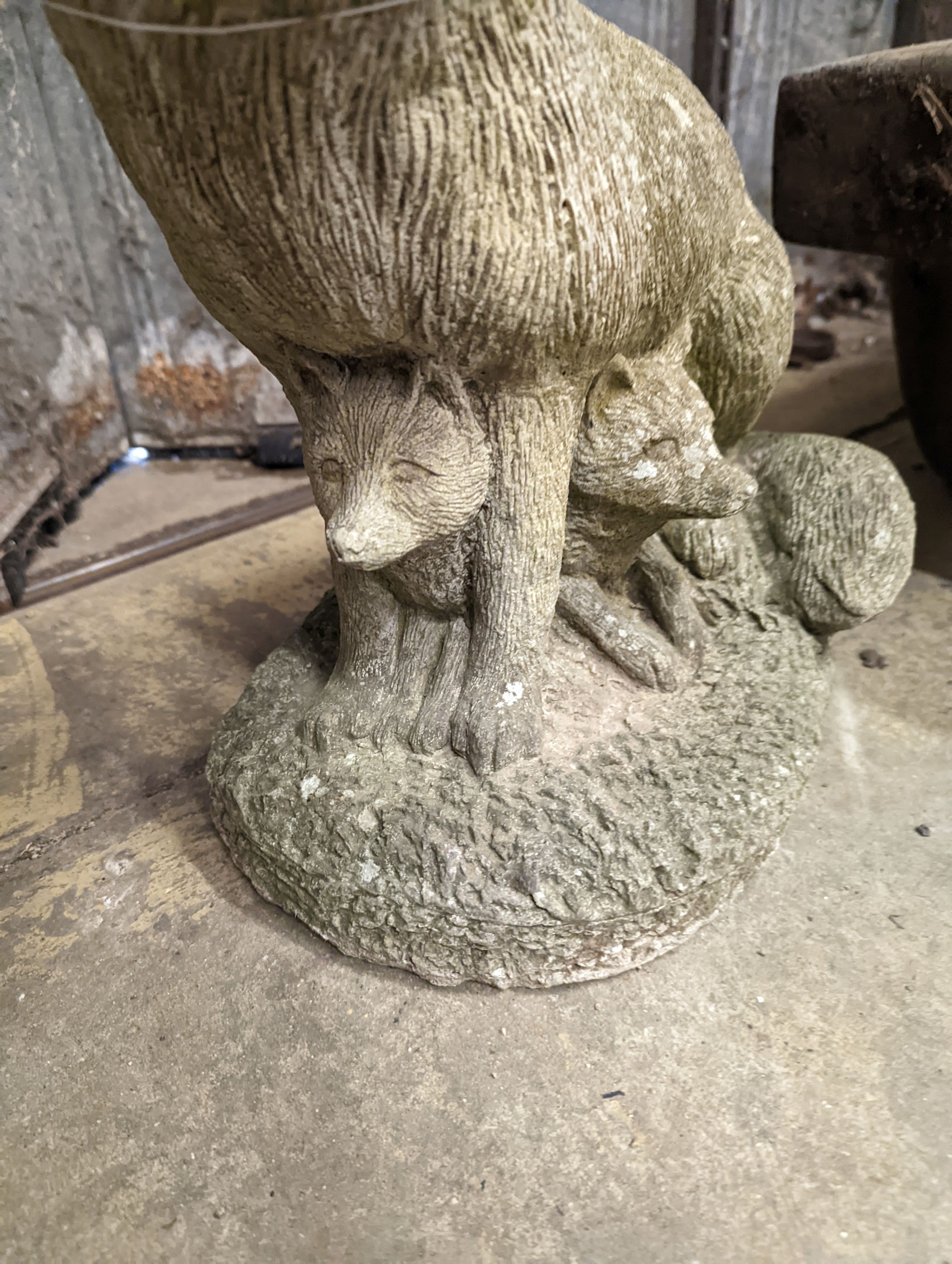 A reconstituted stone garden ornament modelled as a fox with cub, height 42cm