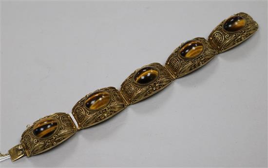 A Chinese silver gilt filligree and cabochon tigers eye quartz set bracelet, 73mm. A Chinese silver gilt filligree and cabochon tigers eye quartz set bracelet, 73mm.