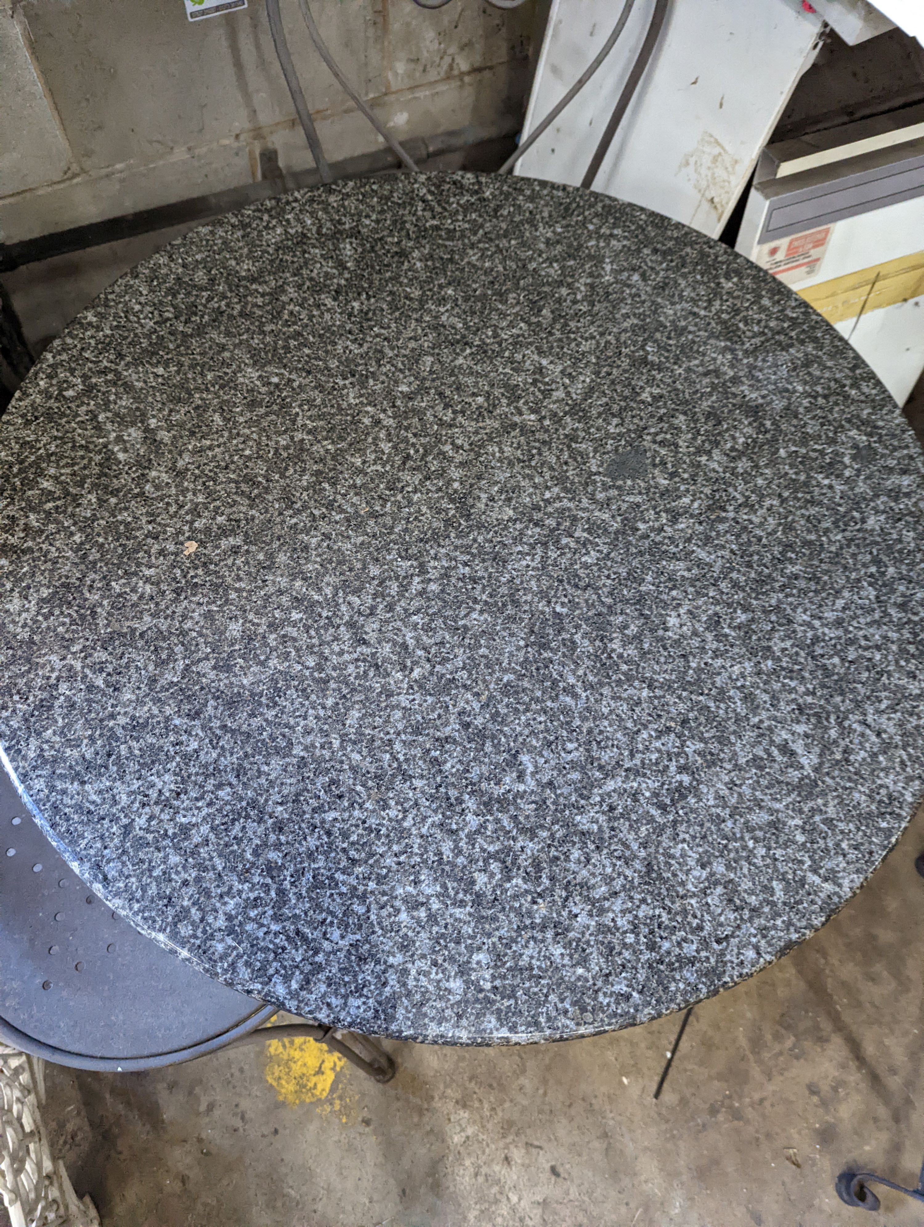 A circular stone top garden table, diameter 75cm, height 72cm and two chairs