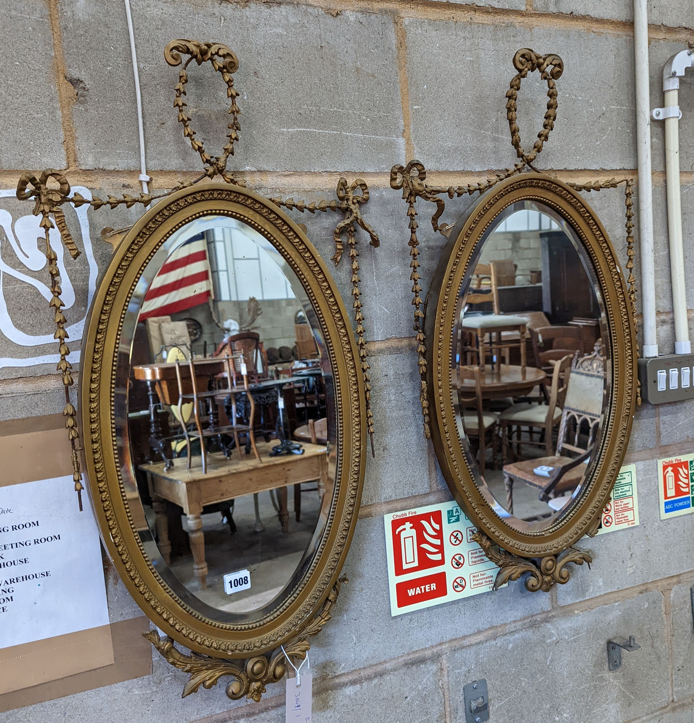 A pair of Edwardian Adam design oval giltwood and gesso wall mirrors, width 43cm, height 80cm