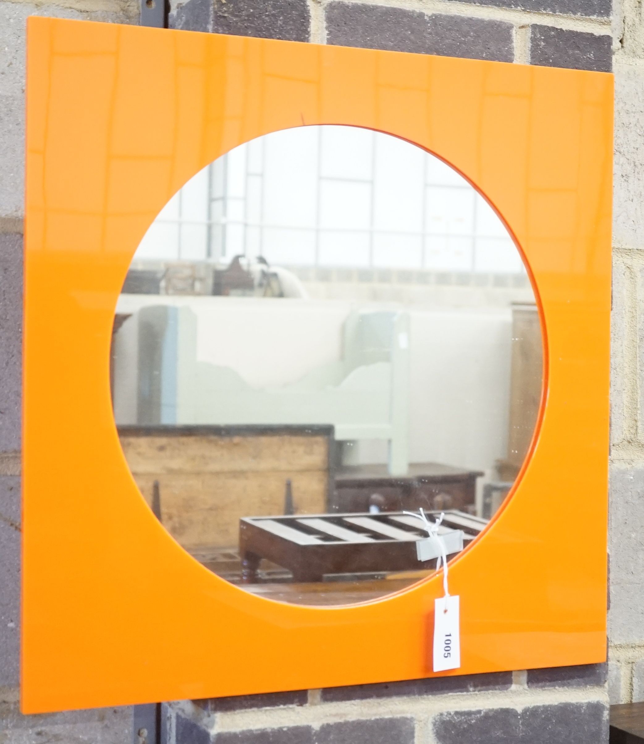 A 1960's orange Perspex framed mirror, 60cm sq.