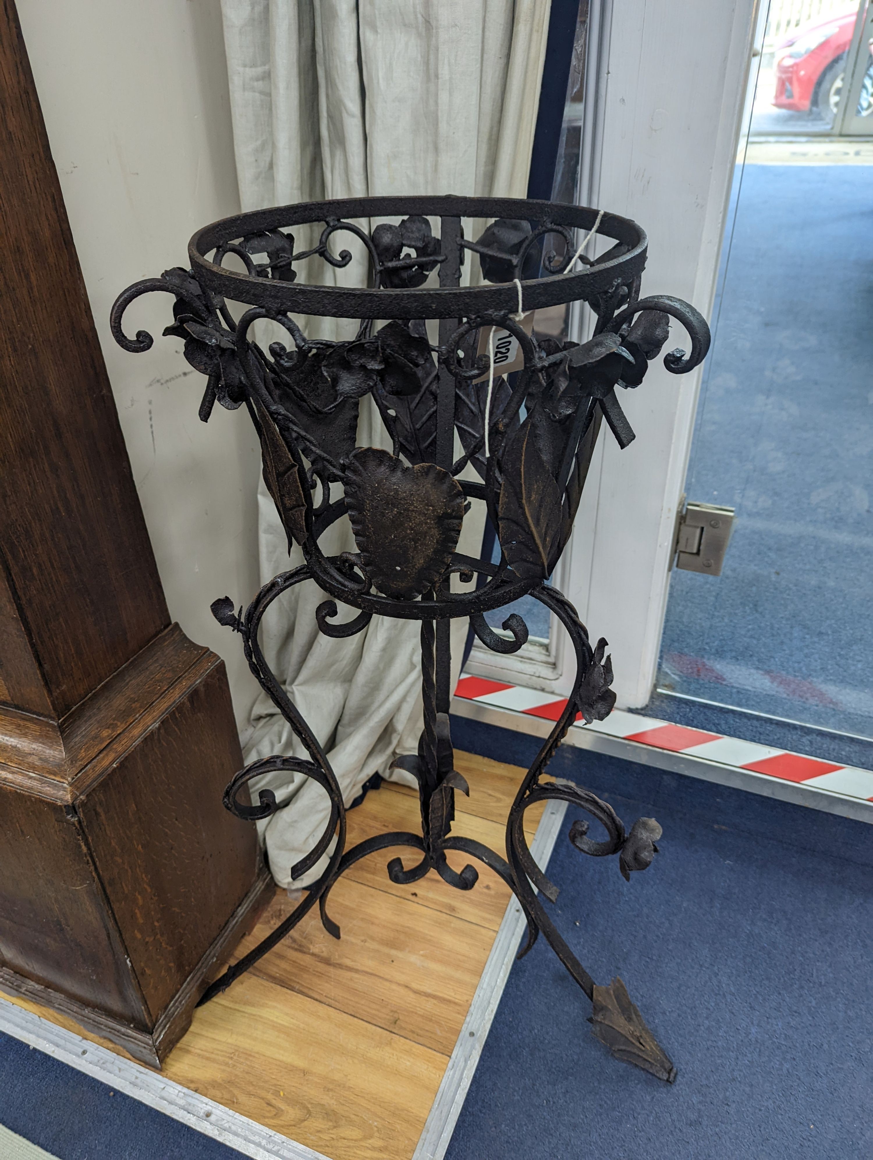 A pair of wrought iron garden planters, no liners, height 81cm