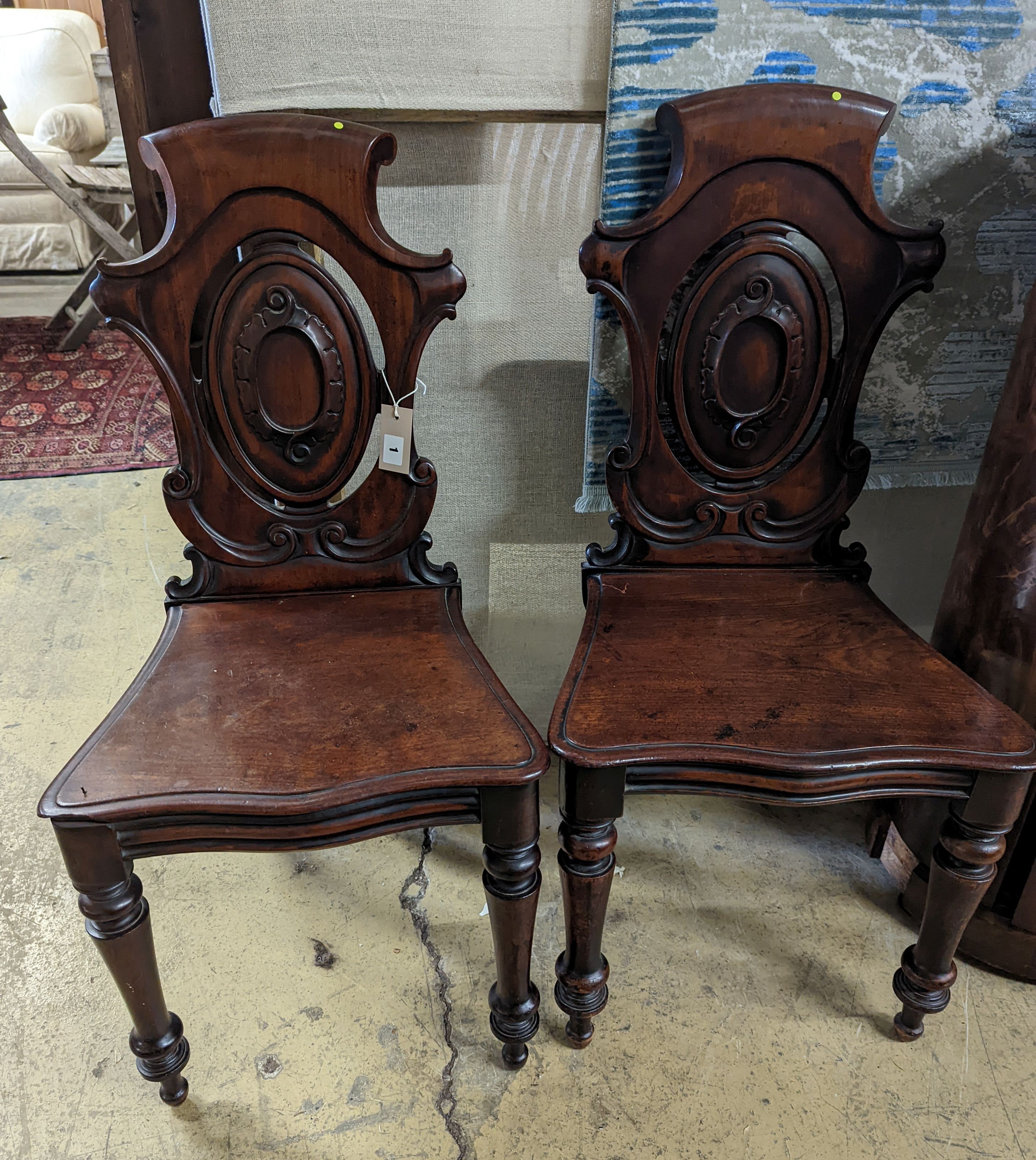A pair of Victorian carved mahogany hall chairs, a.f.