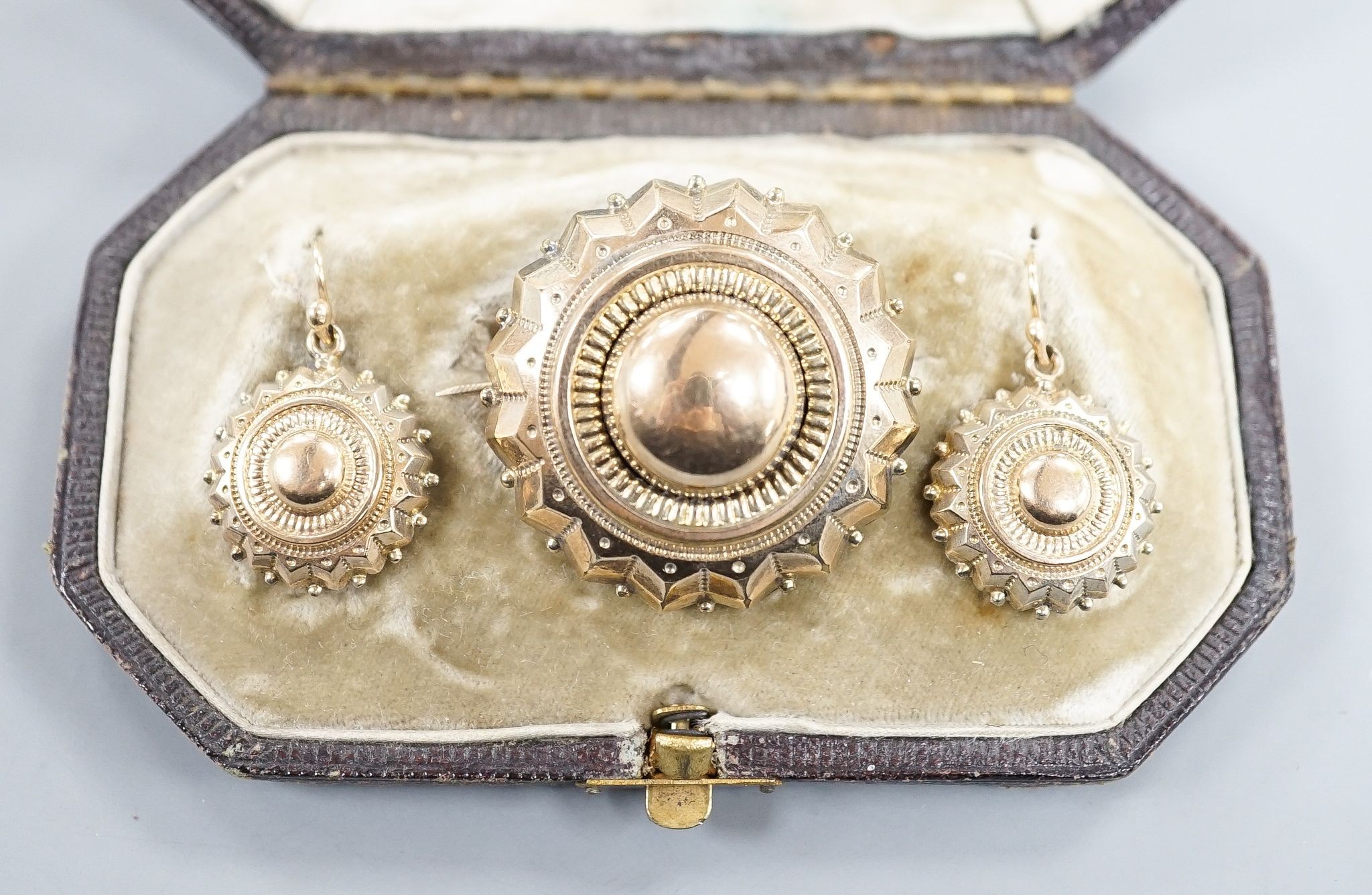 A Victorian yellow metal suite of jewellery, comprising a brooch and pair of earrings, brooch 34mm, gross 11.6 grams.