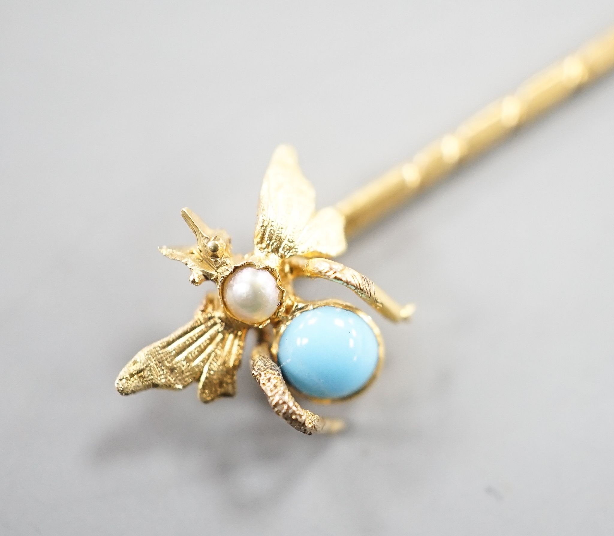 An Edwardian yellow metal, turquoise and seed pearl set bug stick pin, 65mm, gross weight 1.4 grams.