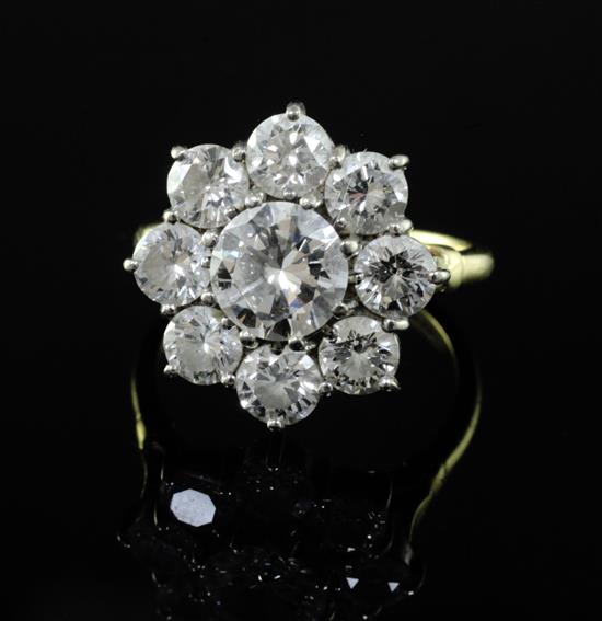 An 18ct gold and nine stone diamond cluster ring, size R. An 18ct gold and nine stone diamond cluster ring, size R.