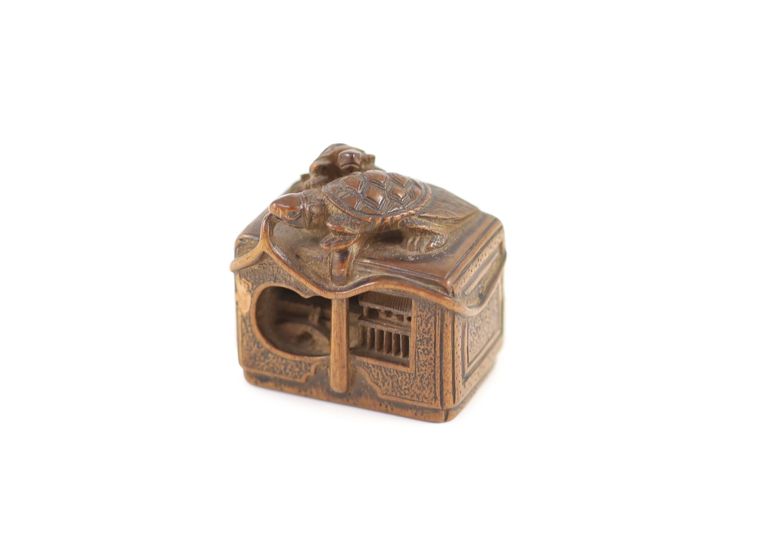 A Japanese boxwood netsuke of a minogame and young perched on the top of a fubako, signed Gyokoku, 19th century, 3.5cm wide