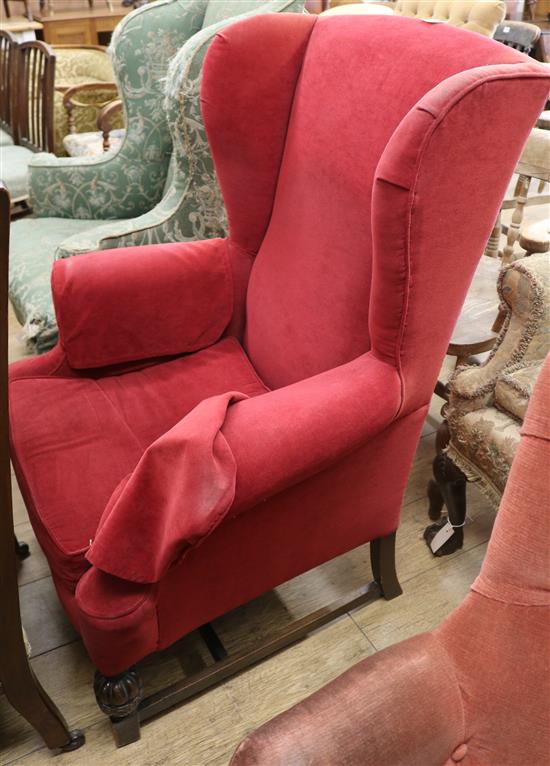 A Georgian style upholstered wing armchair A Georgian style upholstered wing armchair