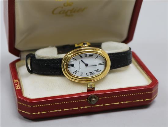 A ladys 18ct gold Cartier oval cased wrist watch, with Cartier box. A ladys 18ct gold Cartier oval cased wrist watch, with Cartier box.