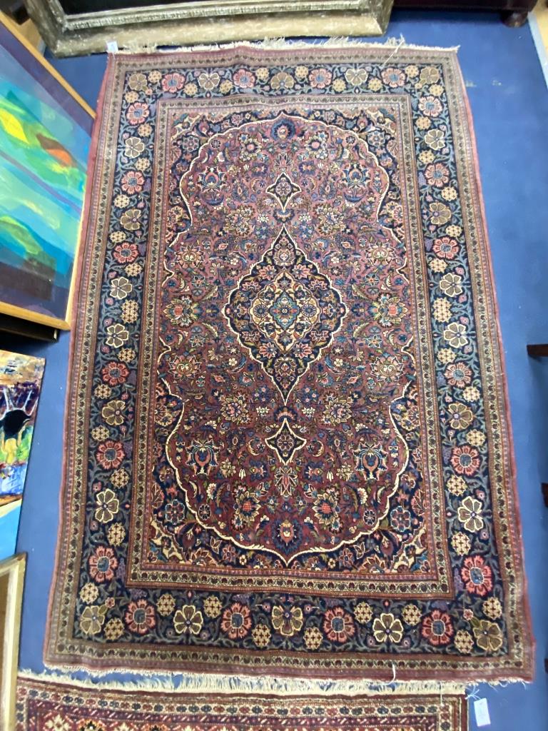 A Kashan burgundy ground rug, 208 x 135cm