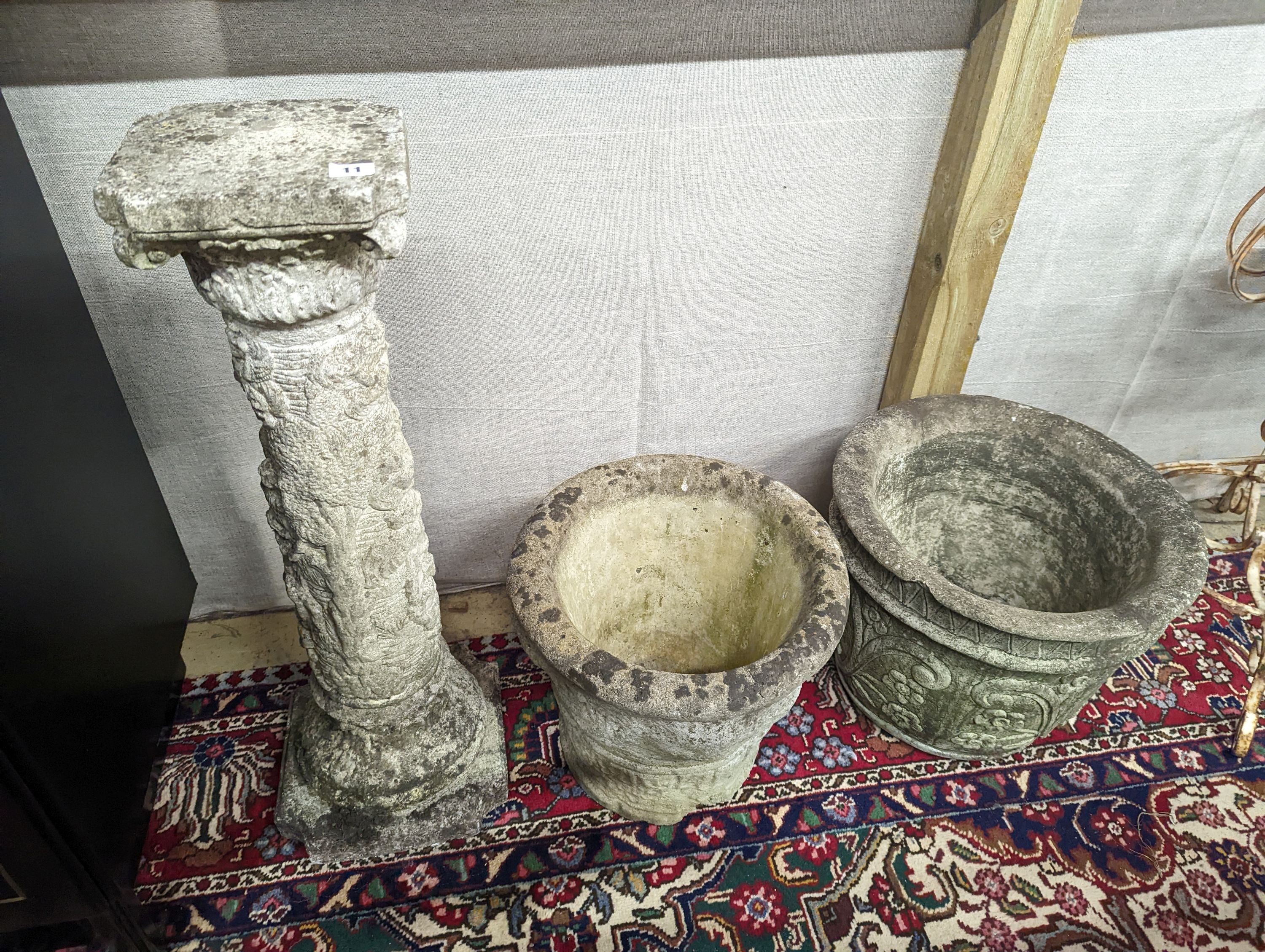 A reconstituted stone garden plinth, height 79cm, together with two circular garden planters, larger diameter 42cm