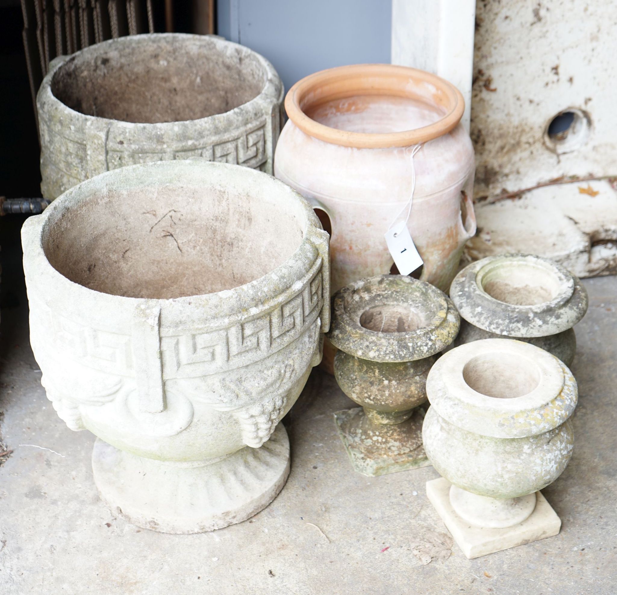 A pair of circular reconstituted stone garden urns, diameter 36cm, a terracotta strawberry pot and three other urns