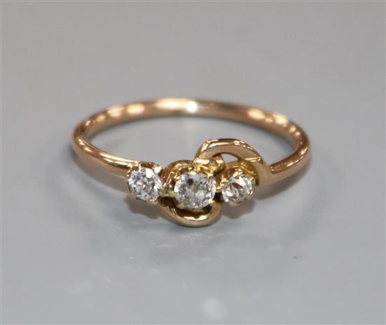 A yellow metal and three stone diamond crossover ring, size L. A yellow metal and three stone diamond crossover ring, size L.
