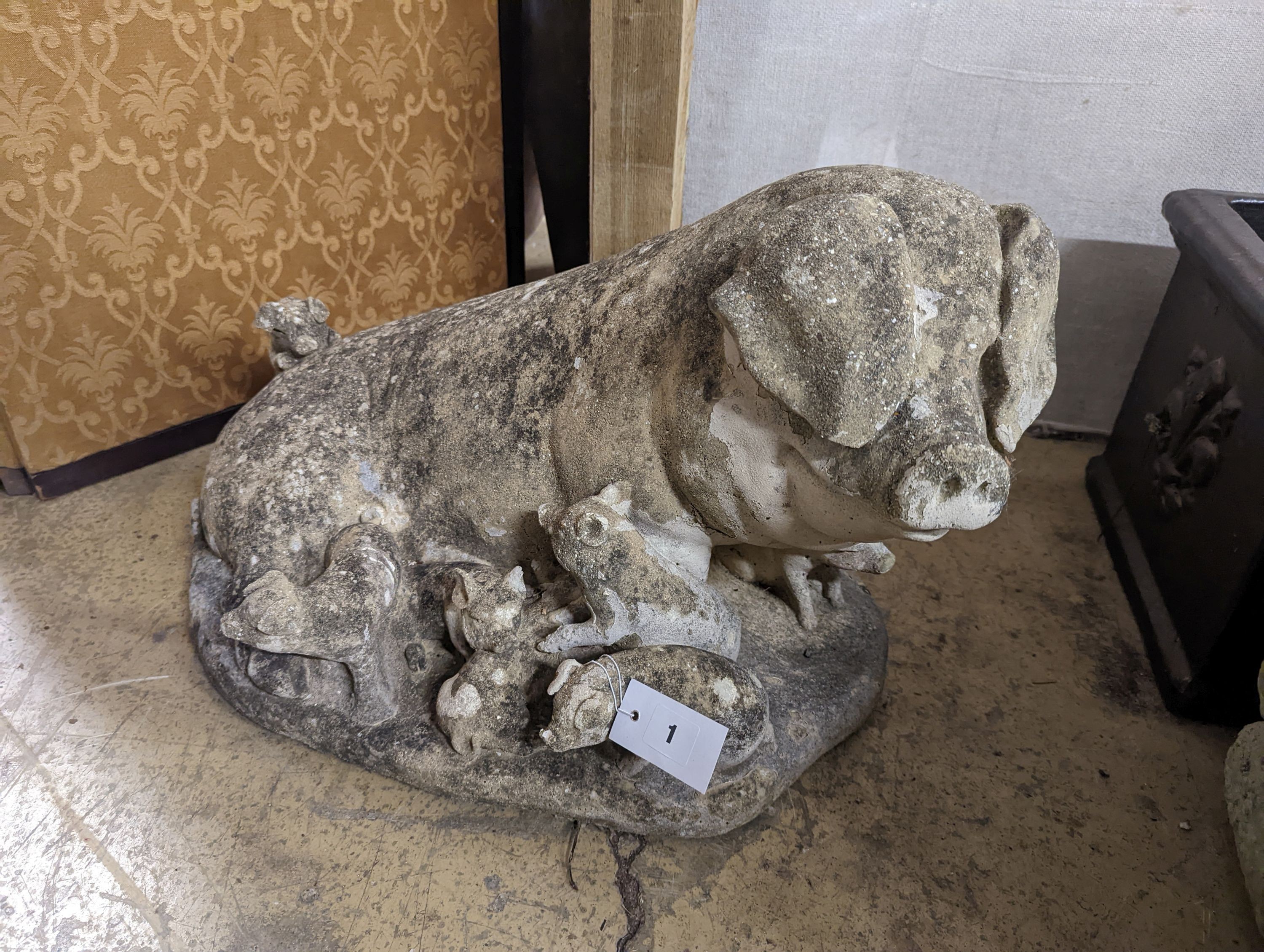 A reconstituted stone garden ornament of a sow with piglets, width 56cm, height 35cm