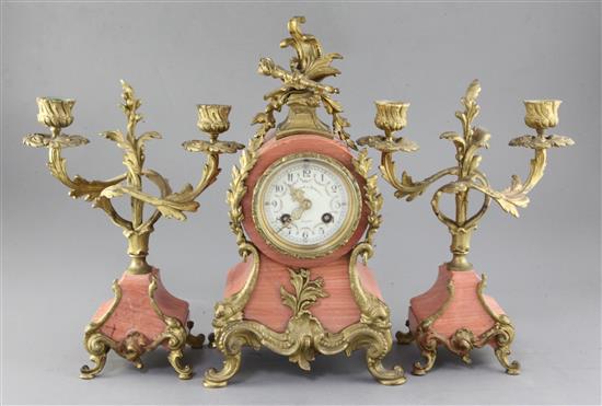 An early 20th century French pink marble clock garniture, 13.5in. An early 20th century French pink marble clock garniture, 13.5in.