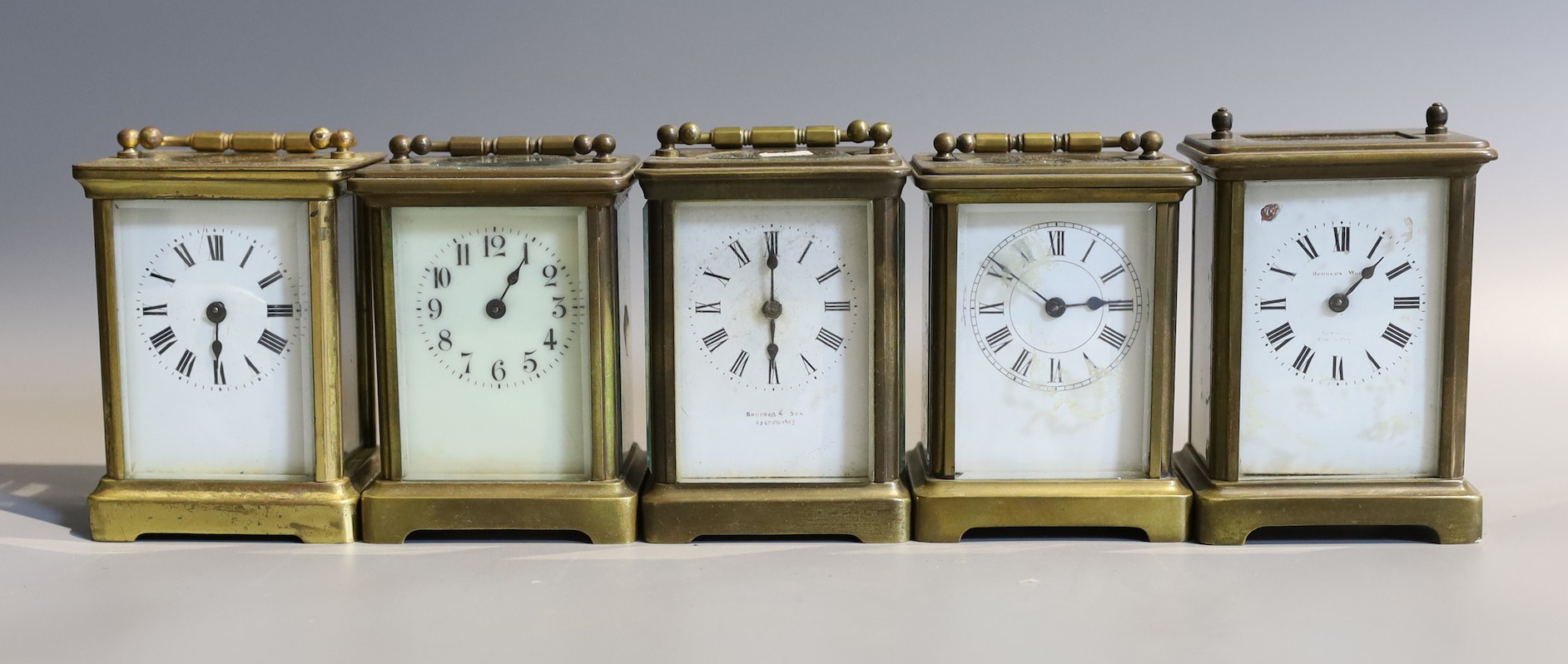 Five early 20th century and later lacquered brass carriage timepieces in various states of repair