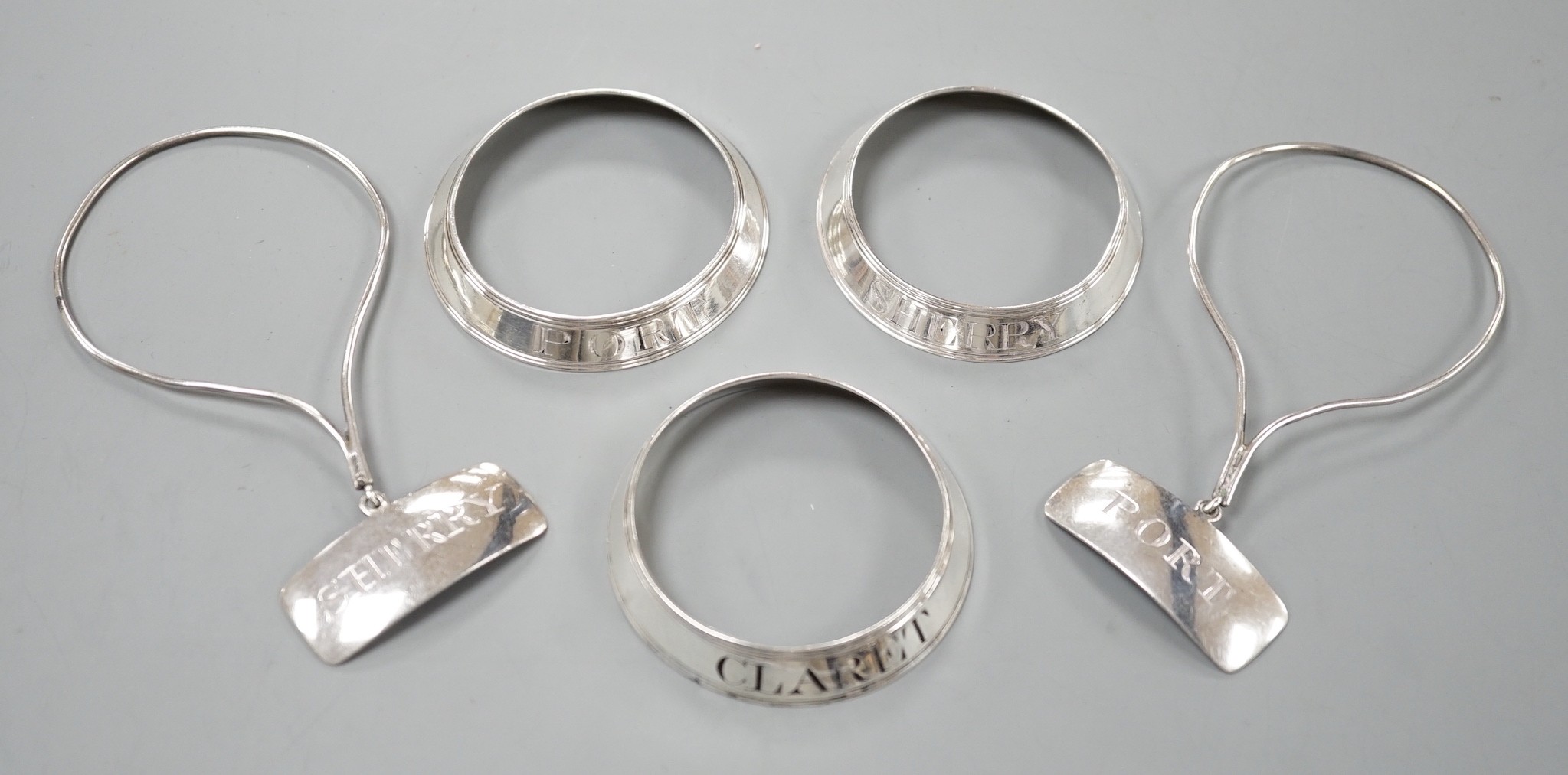 A set of three George silver decanted wine collar labels, Robert Barker, London, 1793 and a pair of similar silver wine label collarettes by Peter & Ann Bateman, London, 1798.                                             