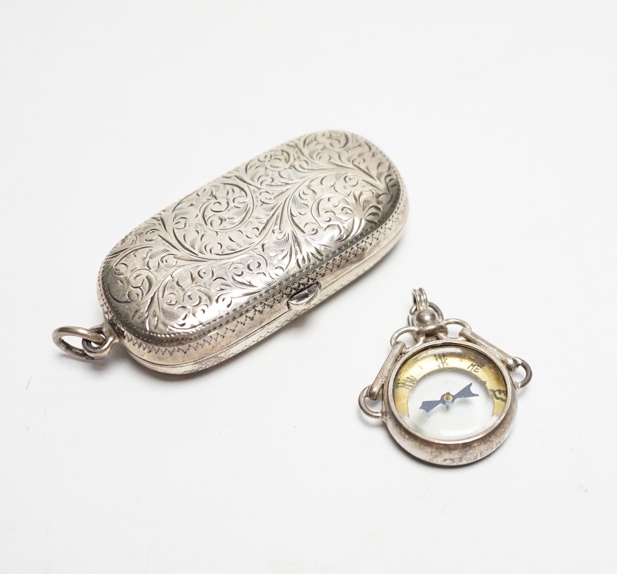 A late Victorian silver twin sovereign case, Chester, 1899 and a George V silver mounted compass fob.                                                                                                                       