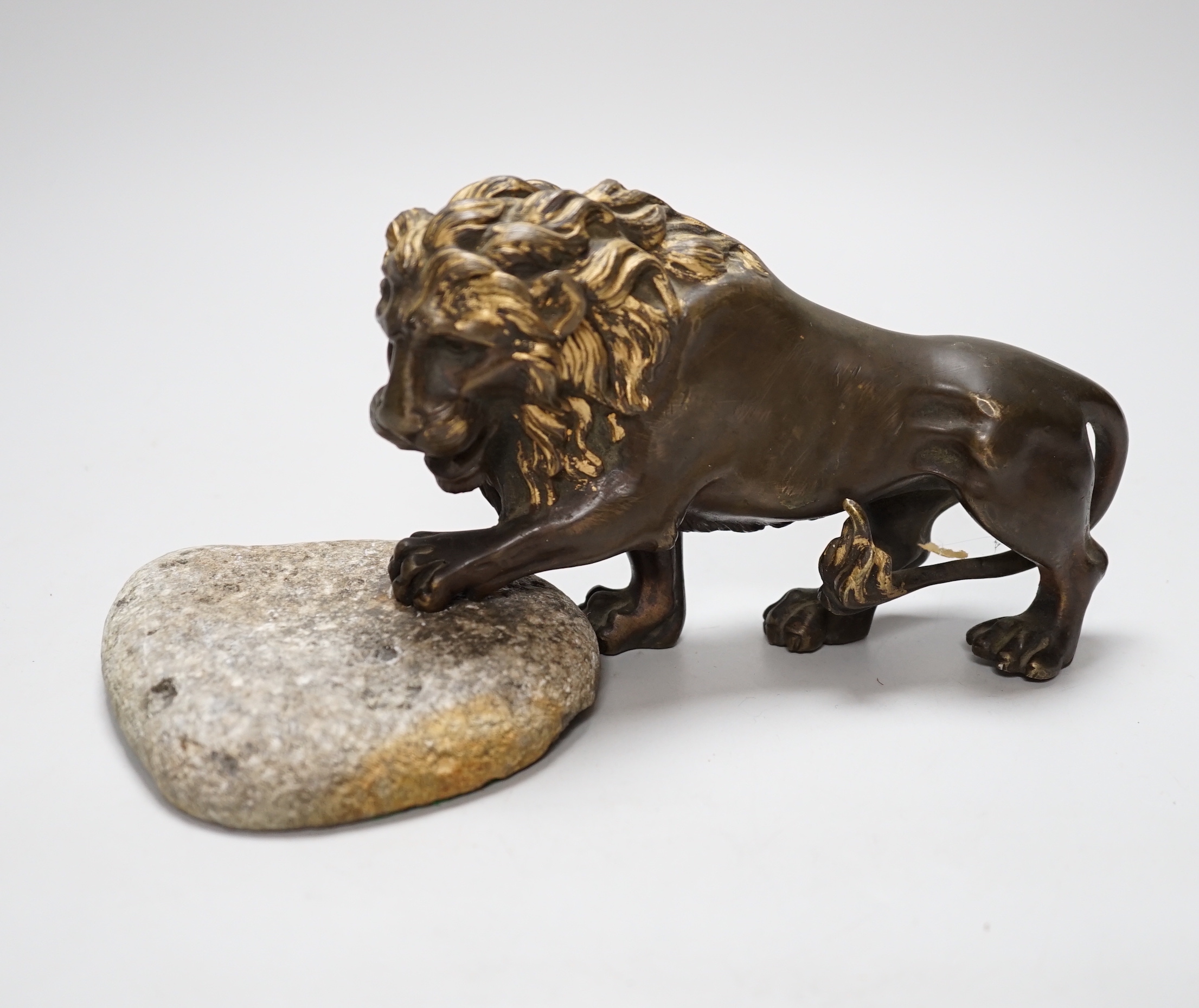 A parcel gilt bronze lion with stone base, 22cm wide                                                                                                                                                                        