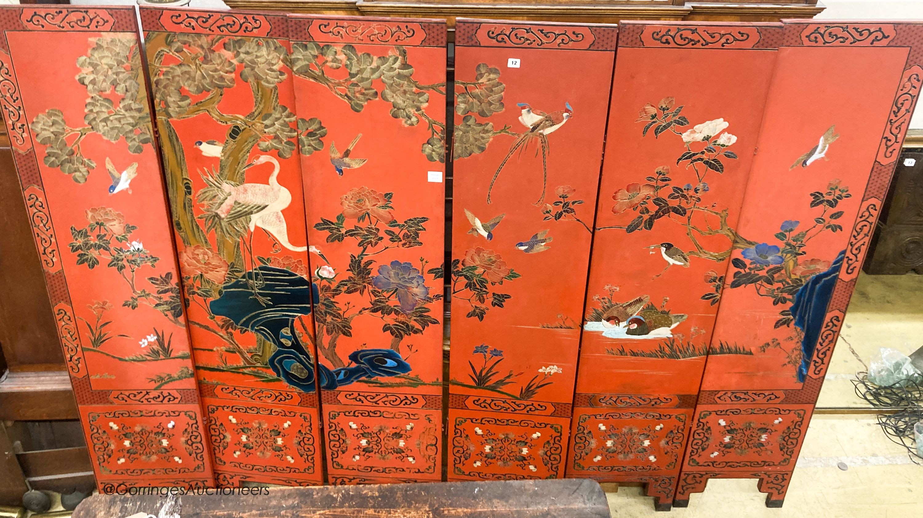 A Chinese red lacquered six fold screen, each panel W.41cm H.184cm                                                                                                                                                          