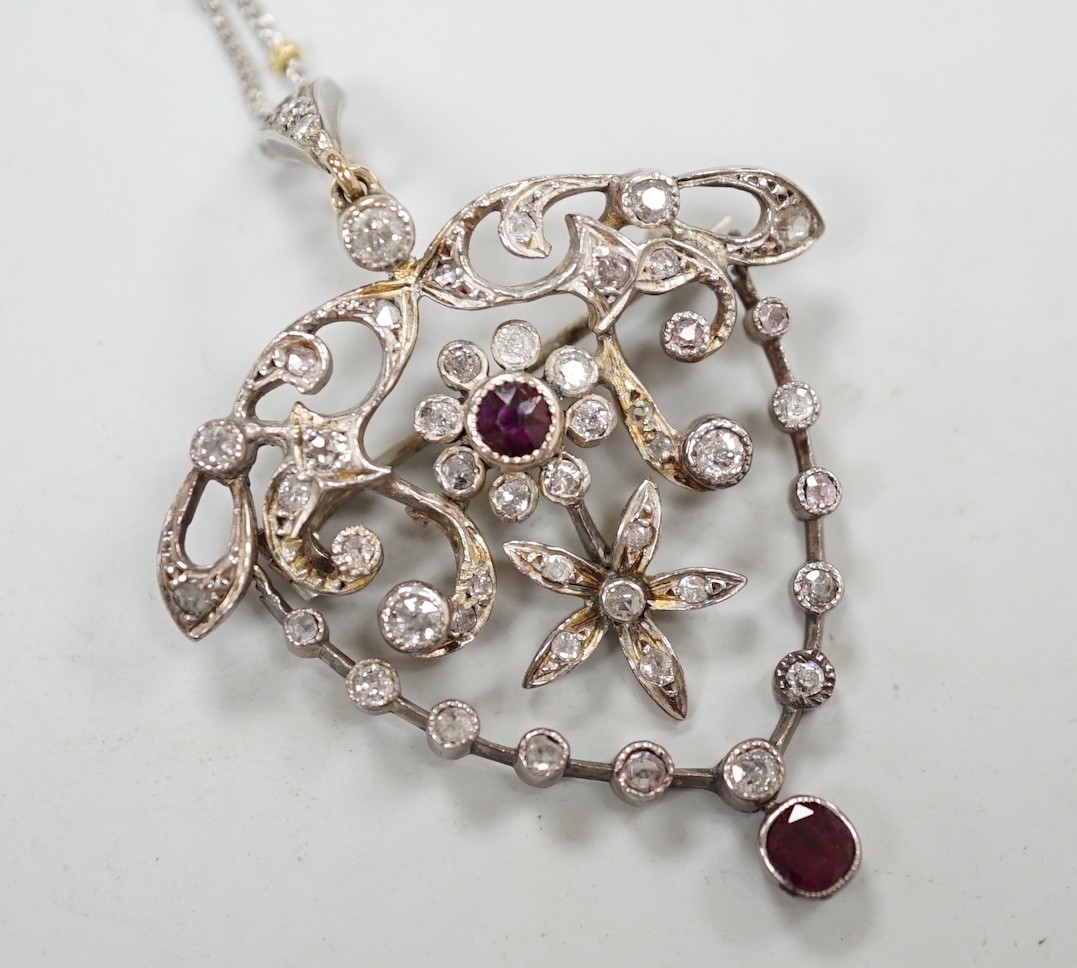 A yellow and white metal, ruby and diamond cluster set drop pendant brooch, 49mm, on an 18ct gold chain, 42cm, gross weight 11.5 grams.                                                                                     