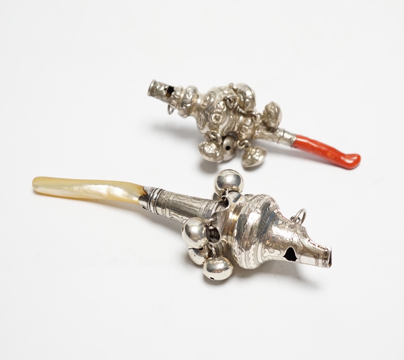 A George III child's silver rattle, with mother of pearl teether, Joseph Wilmore, Birmingham, 1808, 13.5cm and a late Victorian child's silver rattle, with coral teether.                                                  