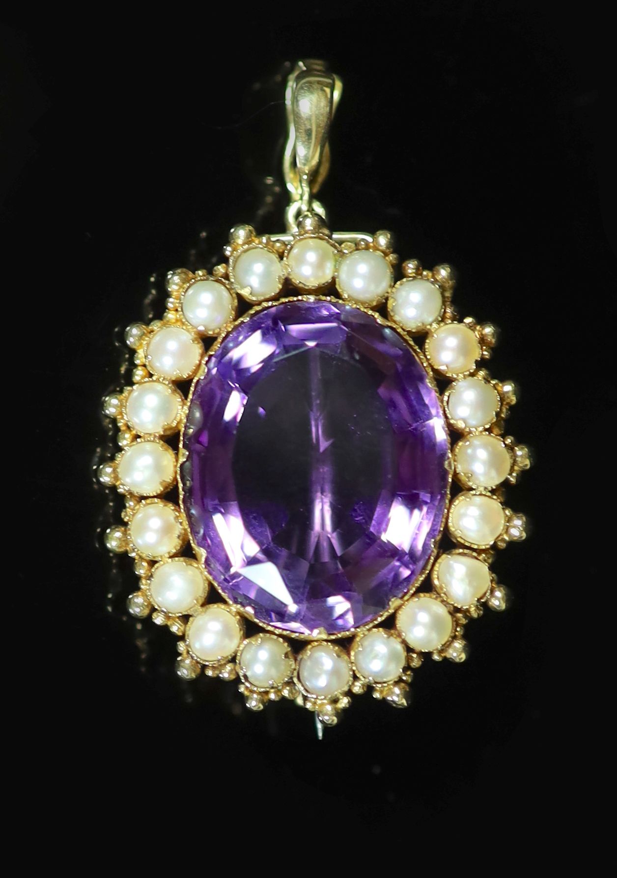 An early 20th century gold, amethyst and split pearl set oval pendant brooch                                                                                                                                                