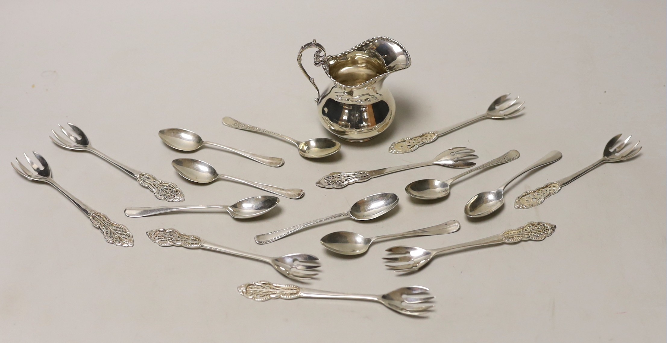 A silver cream jug and sundry minor spoons and forks.                                                                                                                                                                       