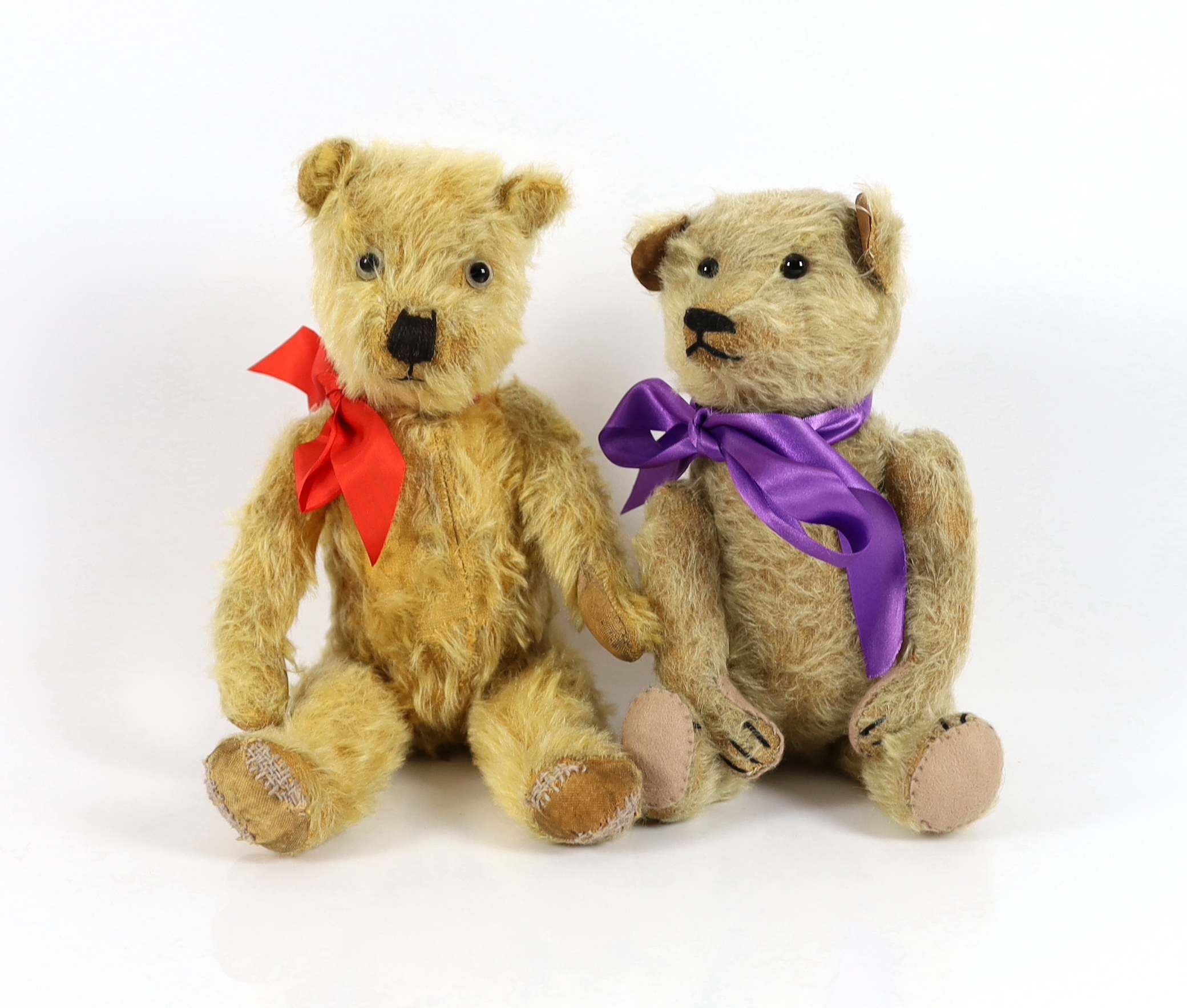A plush covered bear with purple ribbon, 30cm and a plush covered bear with tartan ribbon, 36cm (2)                                                                                                                         