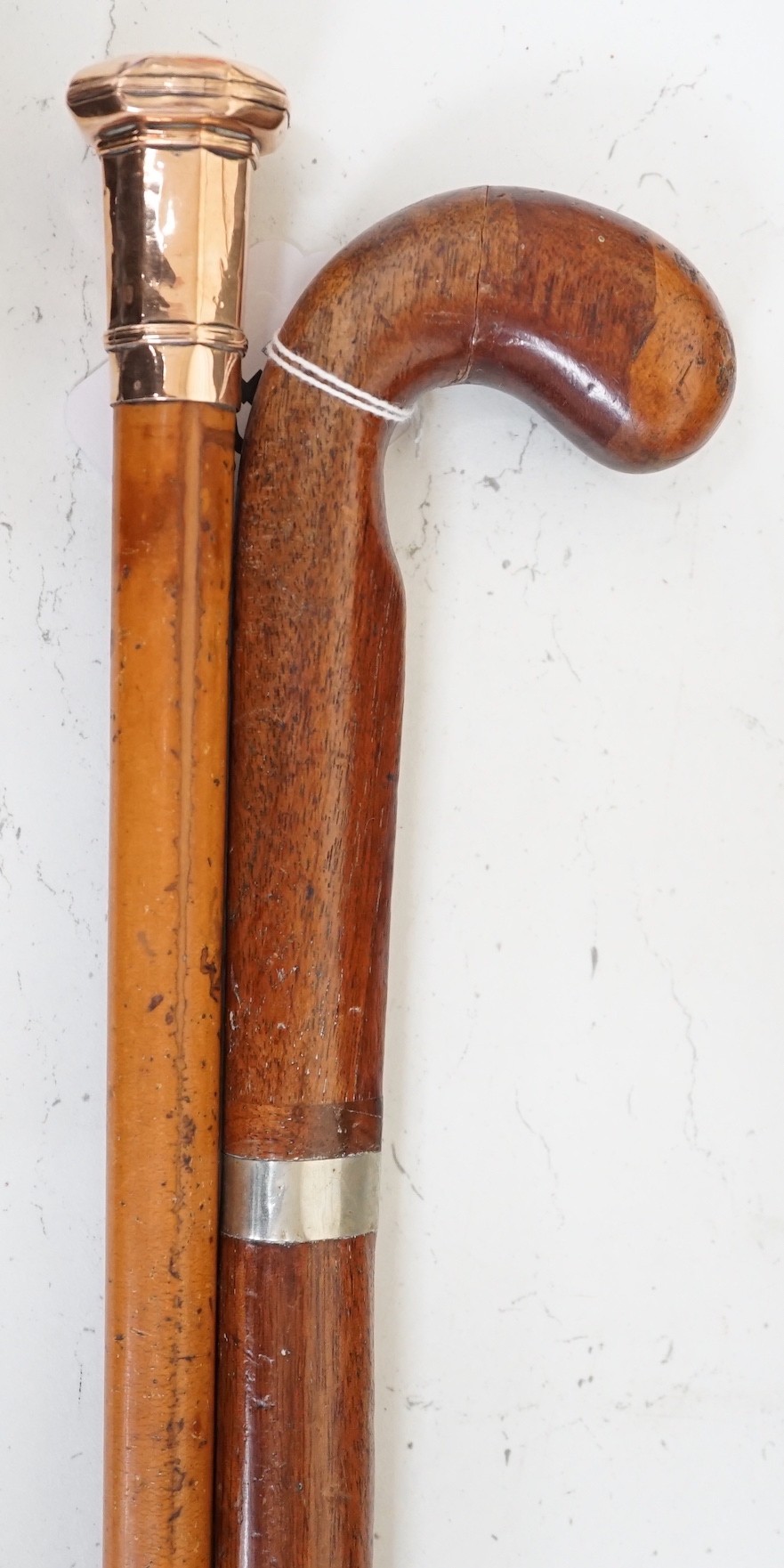 A yellow metal overlay topped walking stick, 91cms long and another (2)                                                                                                                                                     
