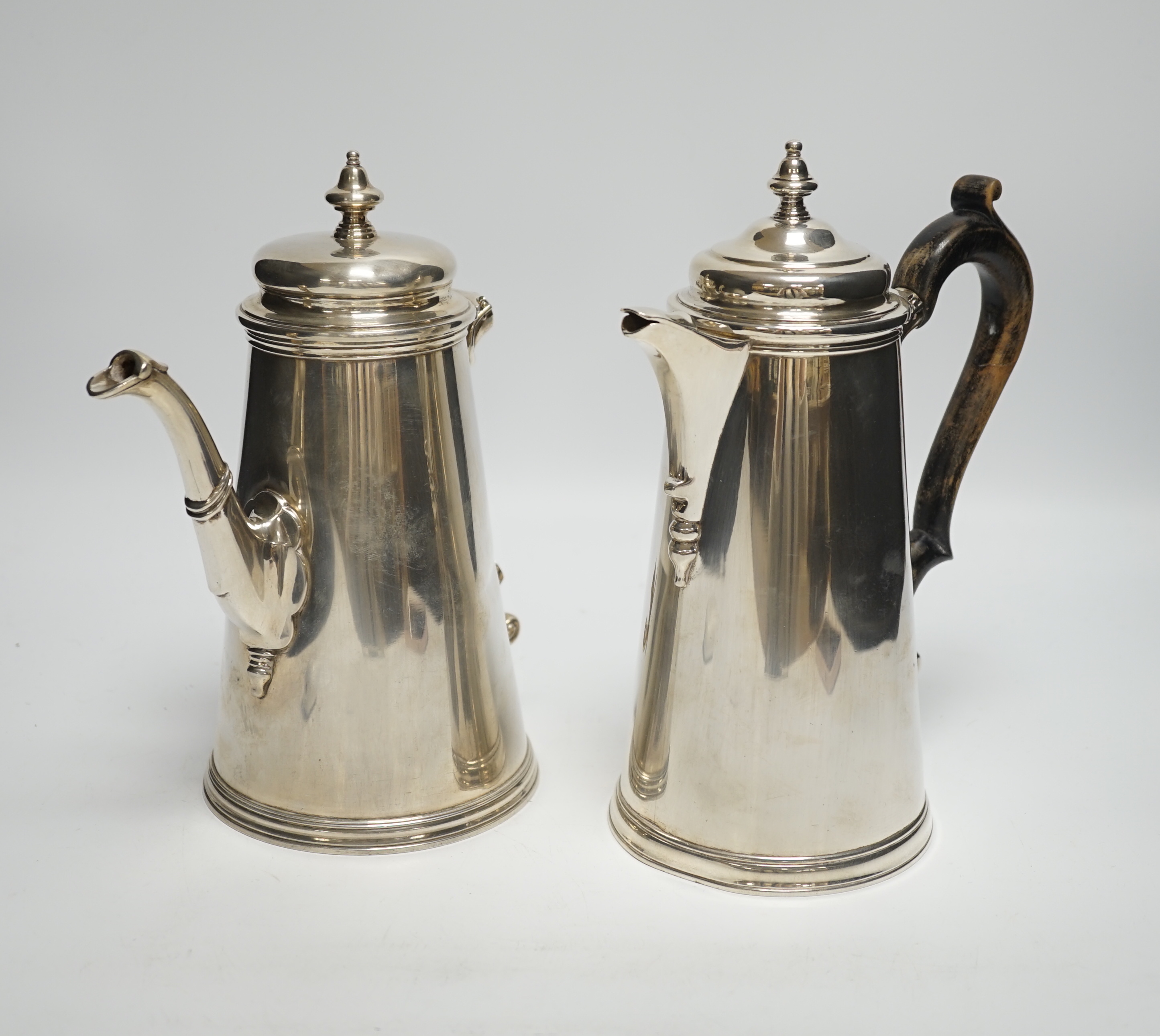 A pair of George V silver cafe au lait pots, Daniel & John Welby, London, 1916/18, handle missing, gross weight 54oz.                                                                                                       