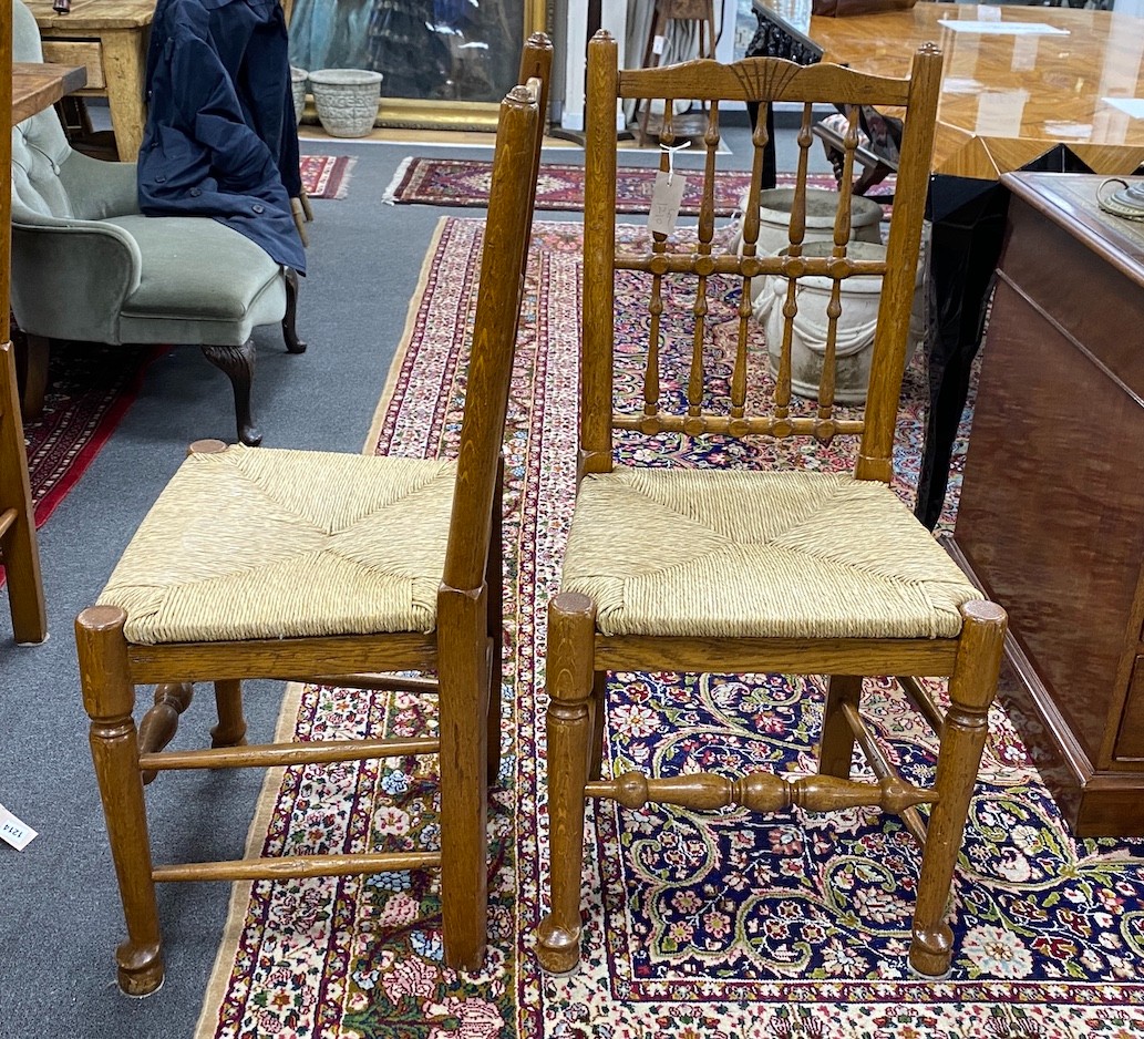 A set of eight Lancashire style oak spindle back rush seat dining chairs                                                                                                                                                    
