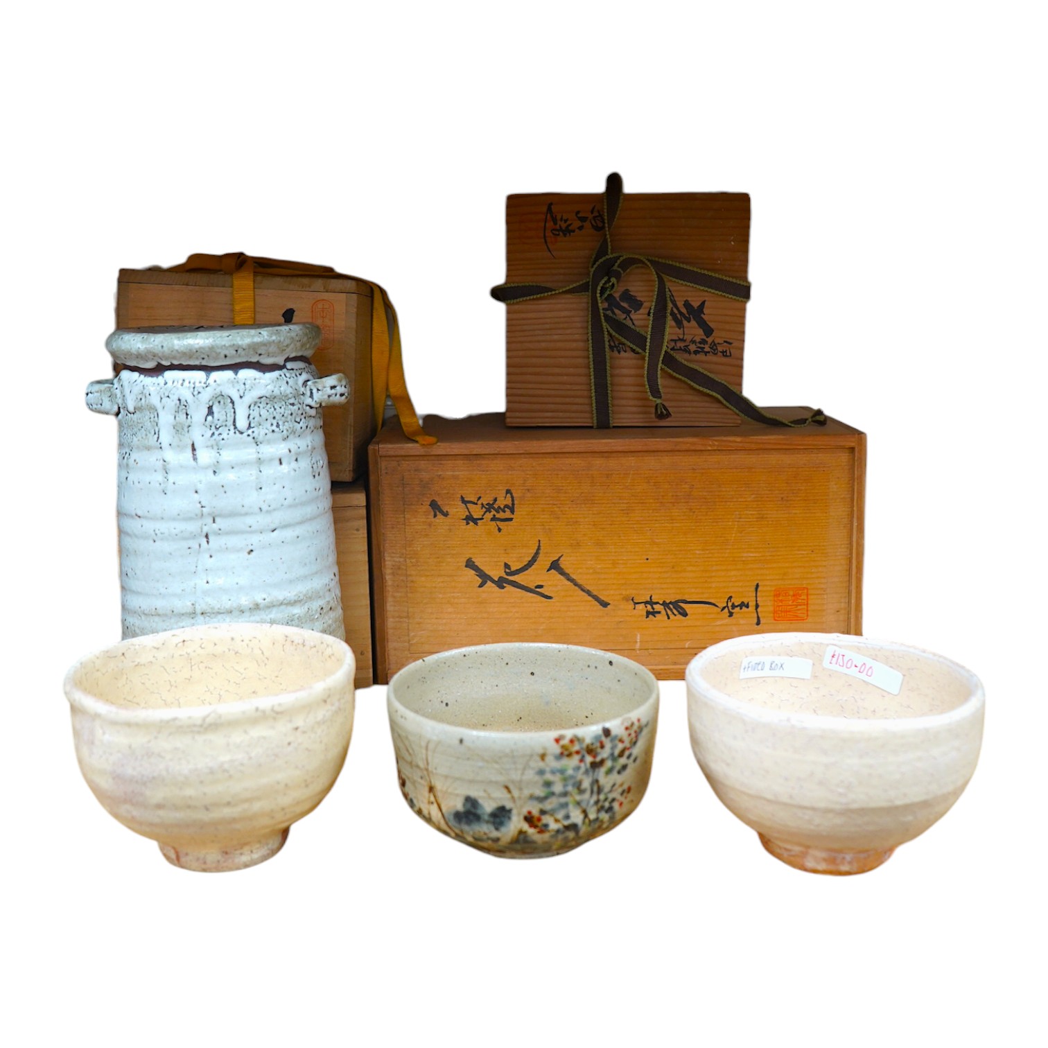 Japanese studio pottery comprising a Nishiyama (Contemporary Japanese School) tea bowl in the Yashichida style decorated with flowers (fitted box), a near pair of Japanese studio pottery cream ground raku bowls (fitted b