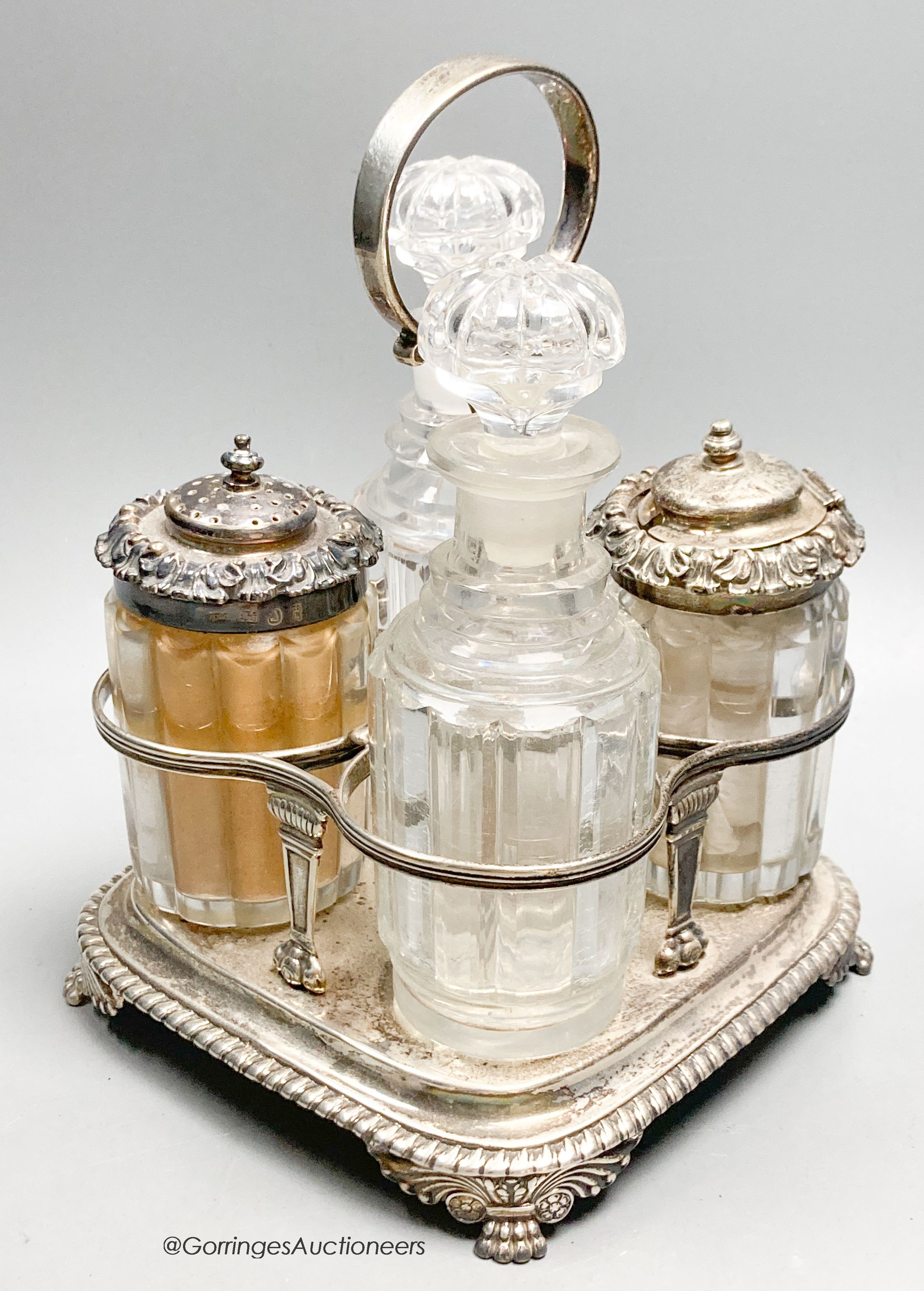 A George III silver cruet stand, by Emes & Barnard, London, 1813 and four associated cruets, two with silver mounts, 21.5cm, 13.5oz.                                                                                        