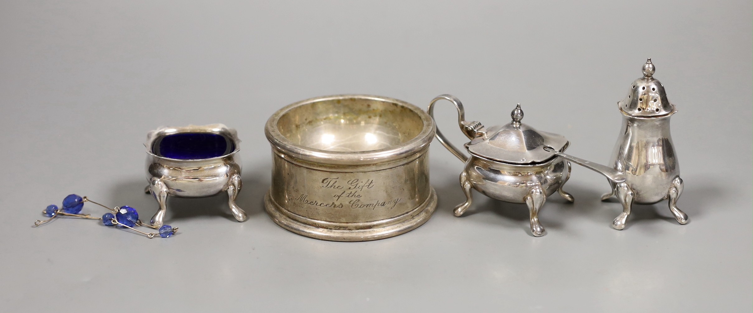 A George V silver jubilee commemorative trencher salt, London 1935, 5oz, and a three piece plated condiment set                                                                                                             
