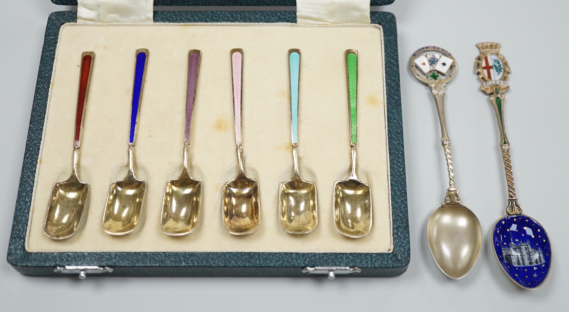 A cased set of six George V silver and polychrome enamel coffee spoons, Barker Bros. Silver Ltd, Birmingham, 1933 and two similar souvenir spoons.                                                                          