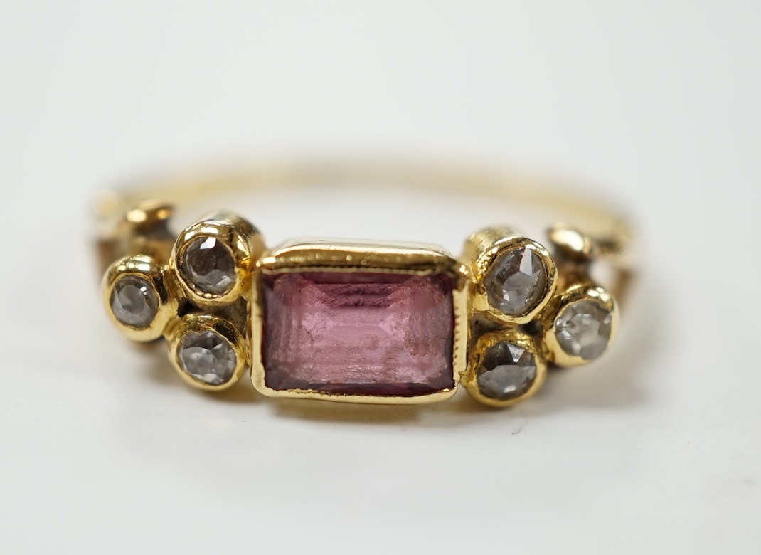 A yellow metal and single stone rectangular cut garnet? set ring, with six stone diamond set shoulders, size L, gross weight 2.5 grams. Condition - poor to fair                                                            