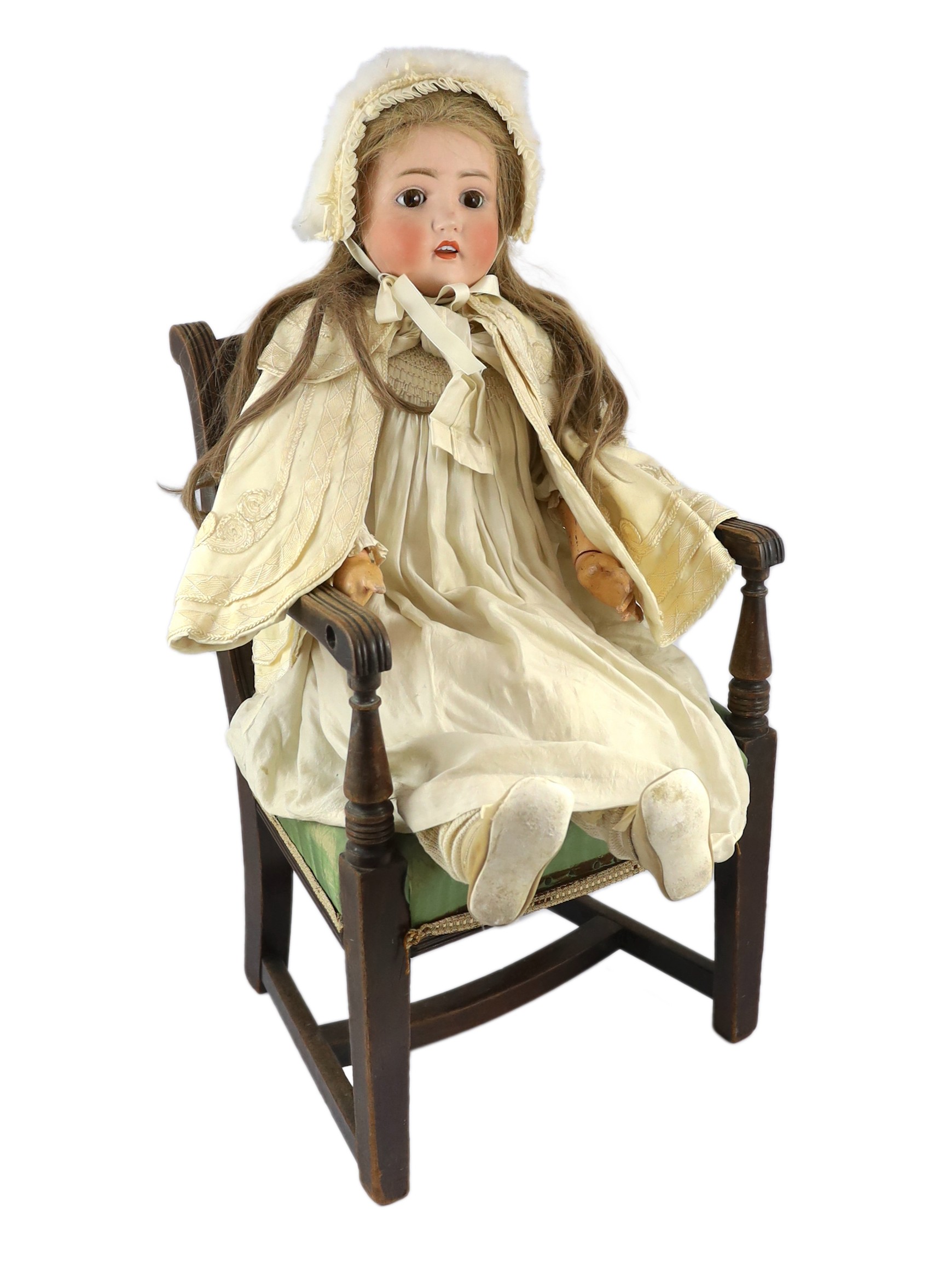 A J.D. Kestner large bisque doll, German, circa 1916, 31in. Please note the chair is for display purposes only.                                                                                                             
