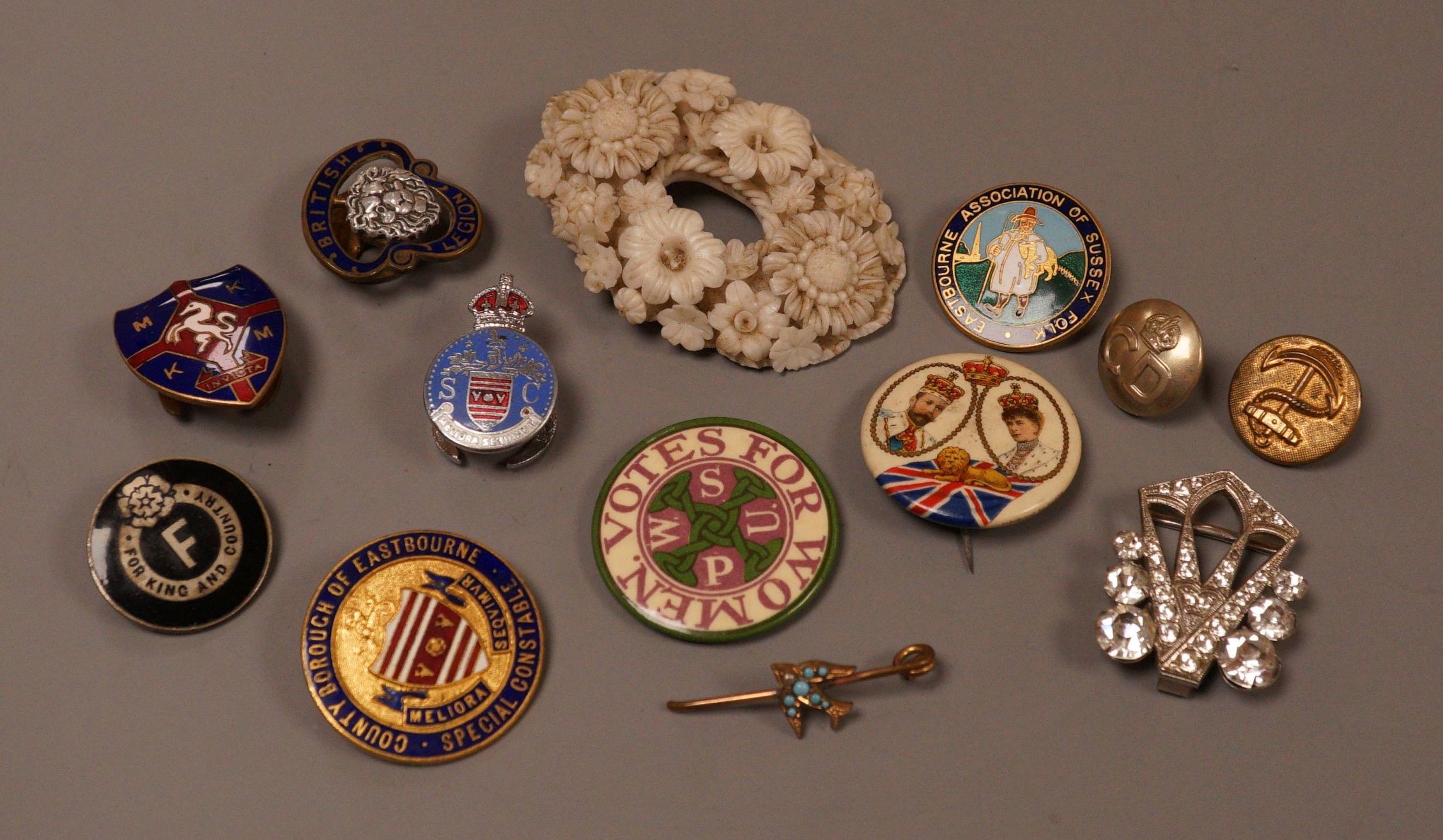 A selection of badges, to include Suffragette Women's Social and Political Union ‘Votes For Women’, Eastbourne Association of Sussex Folk, and others                                                                       