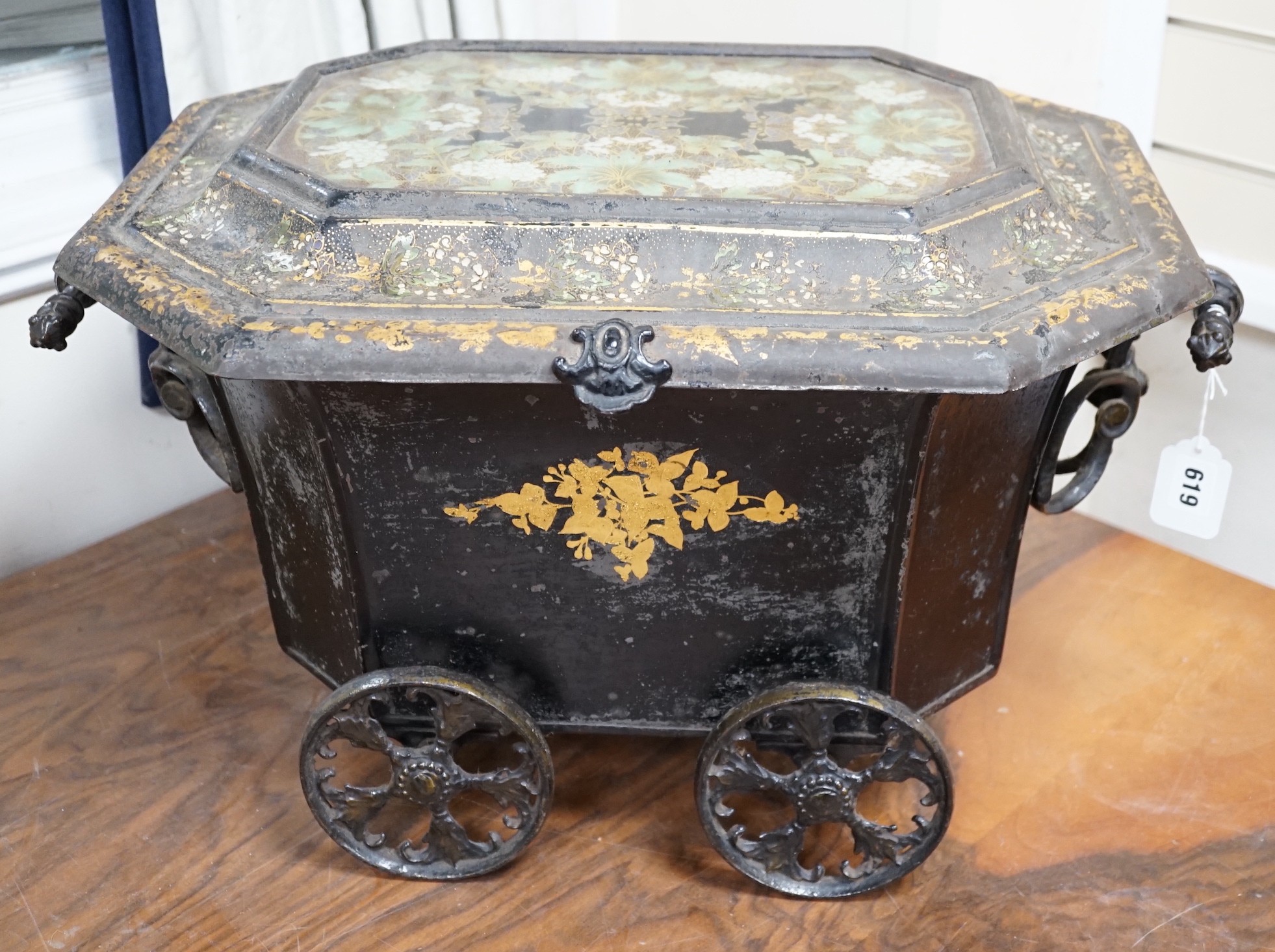 A Victorian gilt lacquer coal scuttle on wheels with glass inset top, 63cm long                                                                                                                                             
