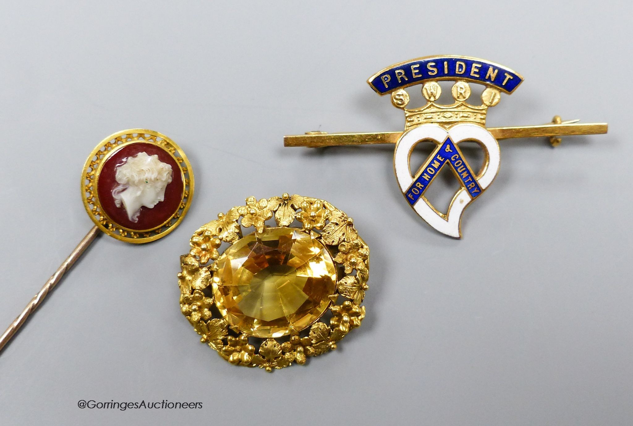 A Victorian gold and citrine brooch, 2.75cm. a hardstone cameo set pin and a 9ct gold and enamel badge (gross 6.9g.)                                                                                                        