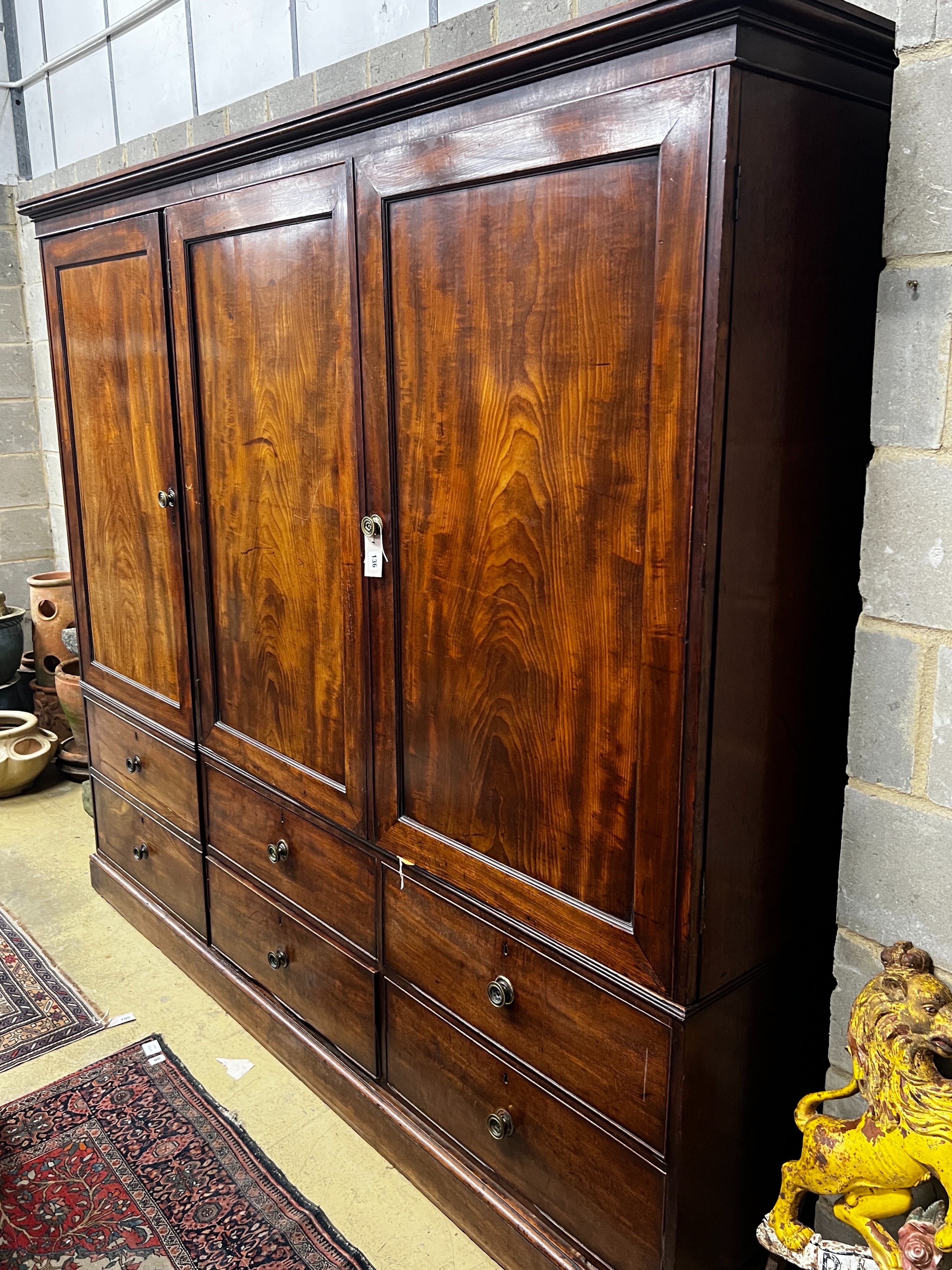 A late 18th century mahogany compactum wardrobe, fitted with three flame mahogany doors, length 217cm, depth 59cm, height 188cm                                                                                             