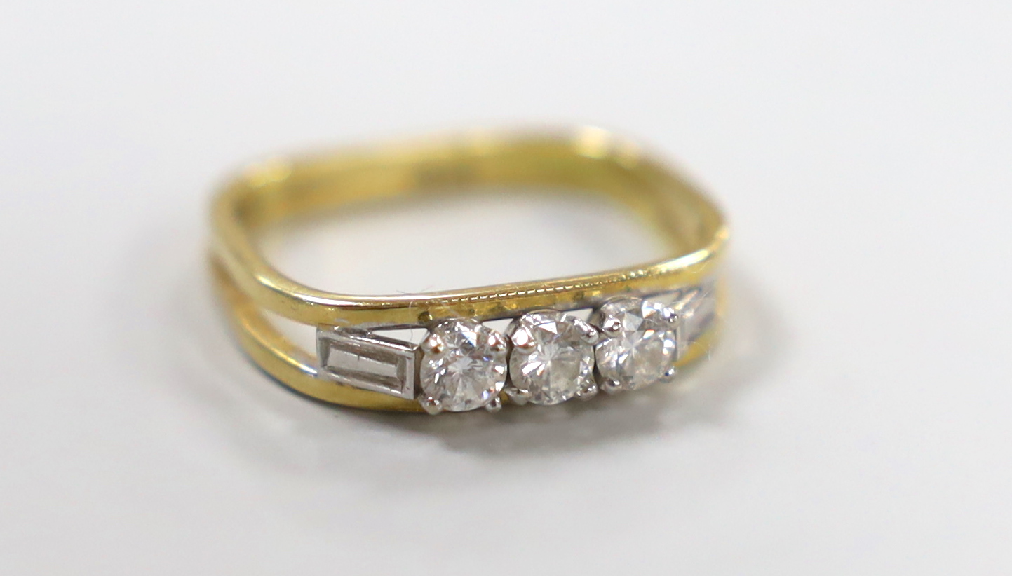 A modern 18ct and three stone diamond ring, with square shank, size approx. L/M, gross weight 2.9 grams.                                                                                                                    