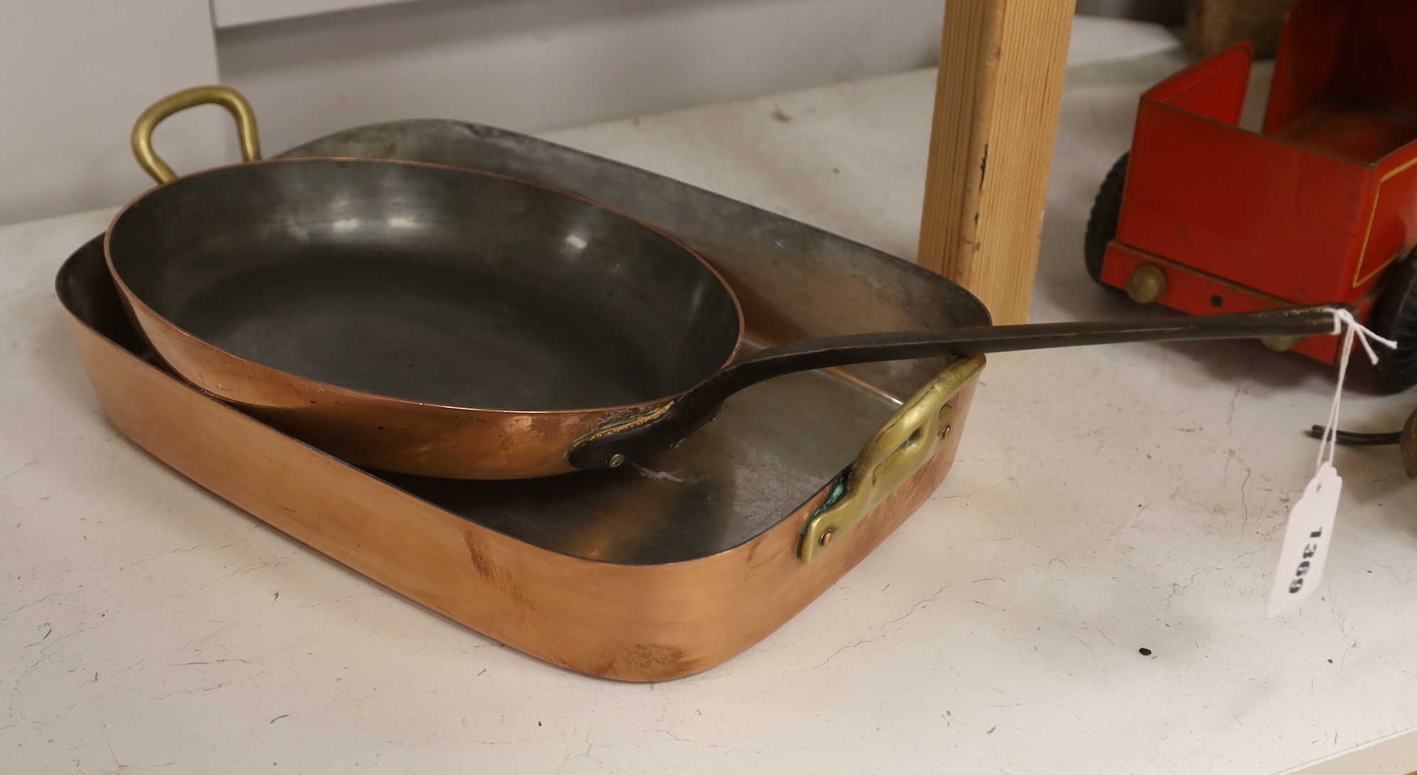 A copper frying pan and similar roasting tin with brass handles, the largest 52cm                                                                                                                                           