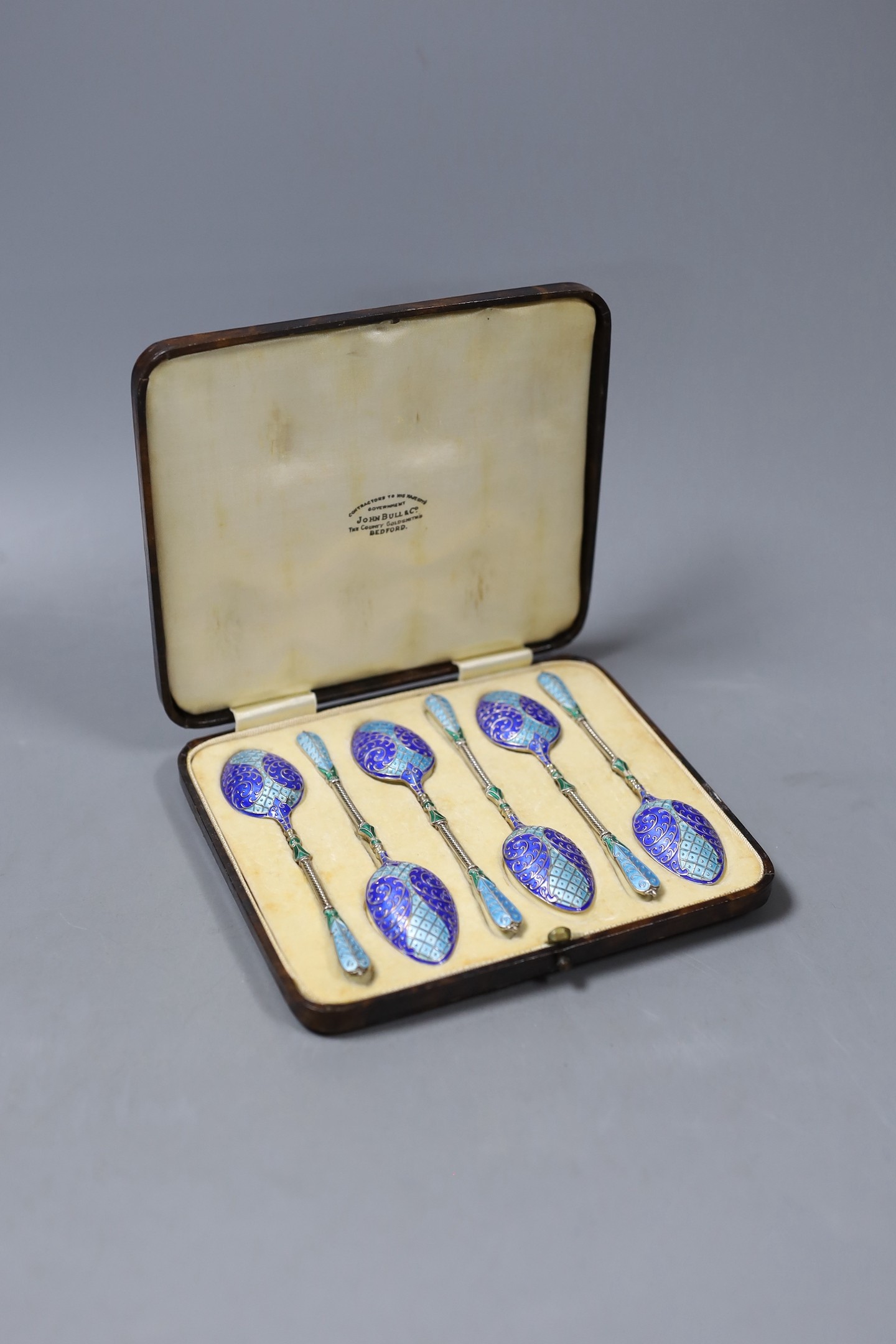 A cased set of six George V silver and three colour enamel teaspoons, Turner & Simpson, Birmingham, 1913, 10.2cm.                                                                                                           
